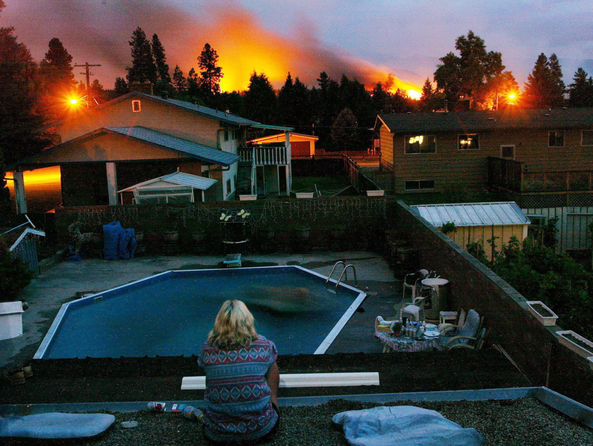 A resident watches the approaching flames in Kelowna on Aug. 22, 2003. More than 2,400 wildfires ravaged B.C. that summer. (THE CANADIAN PRESS/Rich Lam)