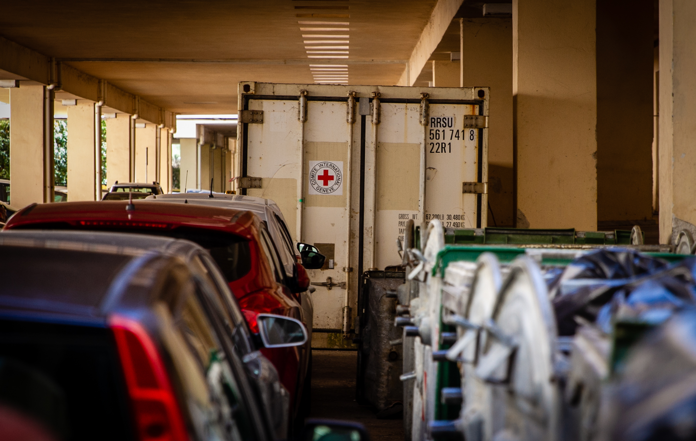 A refrigeration unit storing recovered corpses sits in the parking lot of the Alexandroupoli University Hospital. (Lily Martin/CBC)