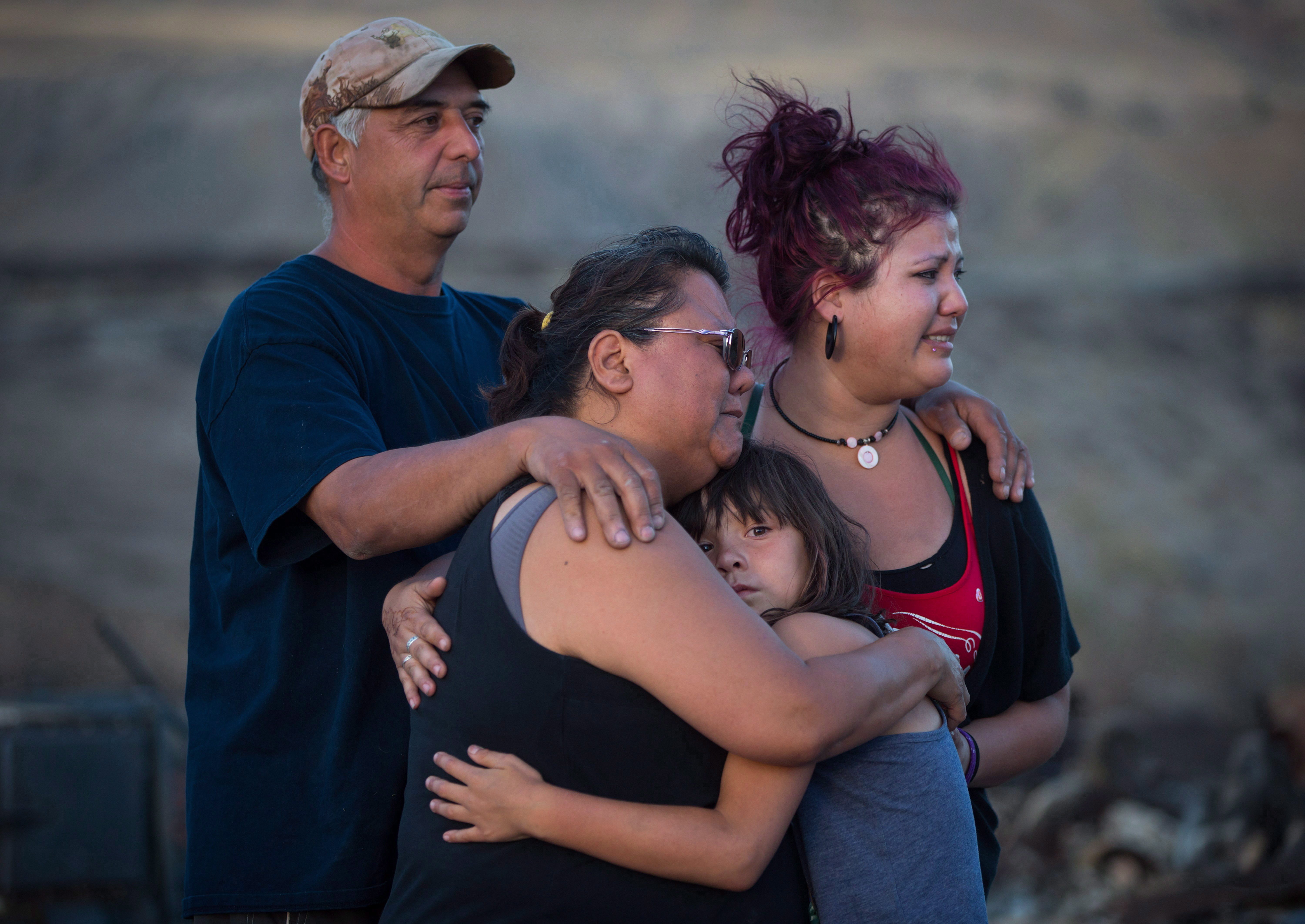 Randy Thorne, left, wife Angie Thorne, second left, daughter Kelsey Thorne, and granddaughter Nevaeh Porter view the wreckage on the Ashcroft Indian Band reserve after their home was destroyed by wildfire in 2017. (THE CANADIAN PRESS/Darryl Dyck)