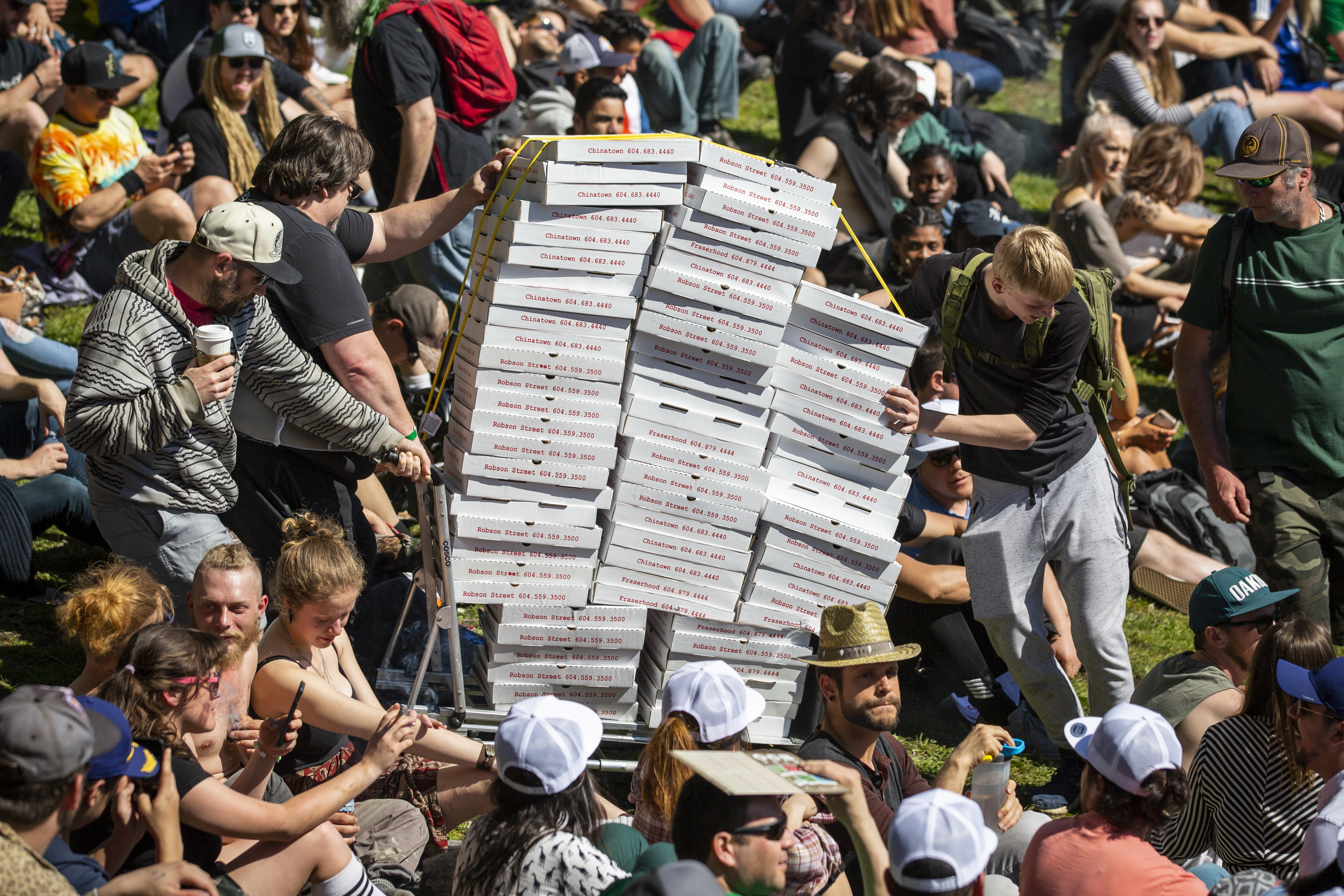 People push a cart of pizza during the annual 420 protest at Sunset Beach in Vancouver on Saturday, April 20, 2019. The 420 celebration — which organizers describe as a protest — features numerous cannabis vendors and a free concert by the hip hop group Cypress Hill. (Ben Nelms/CBC)