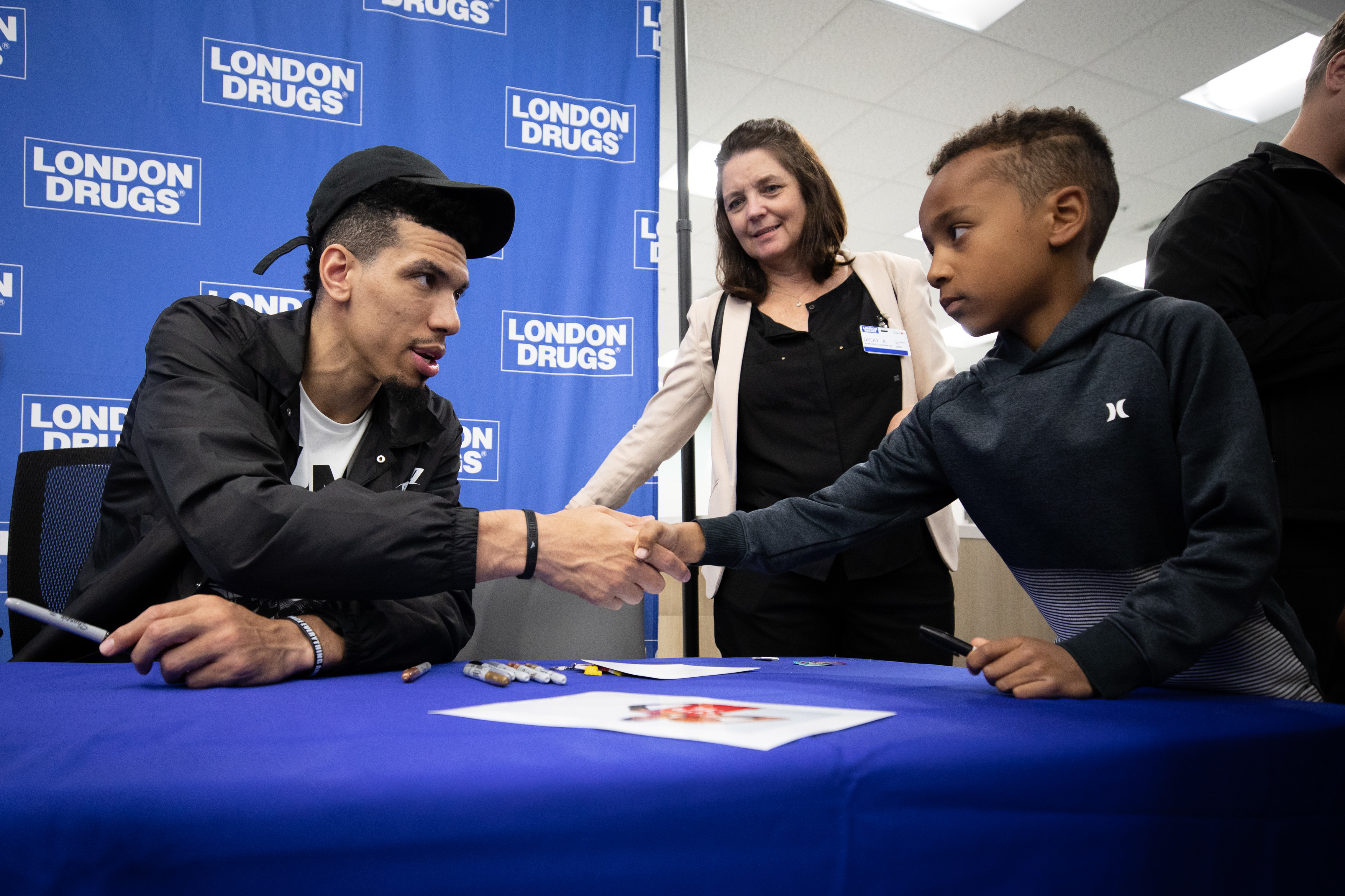 Danny Green, former Toronto Raptors basketball player, shakes hands with a young fan at London Drugs in Vancouver on July 5, 2019. (Maggie MacPherson/CBC)