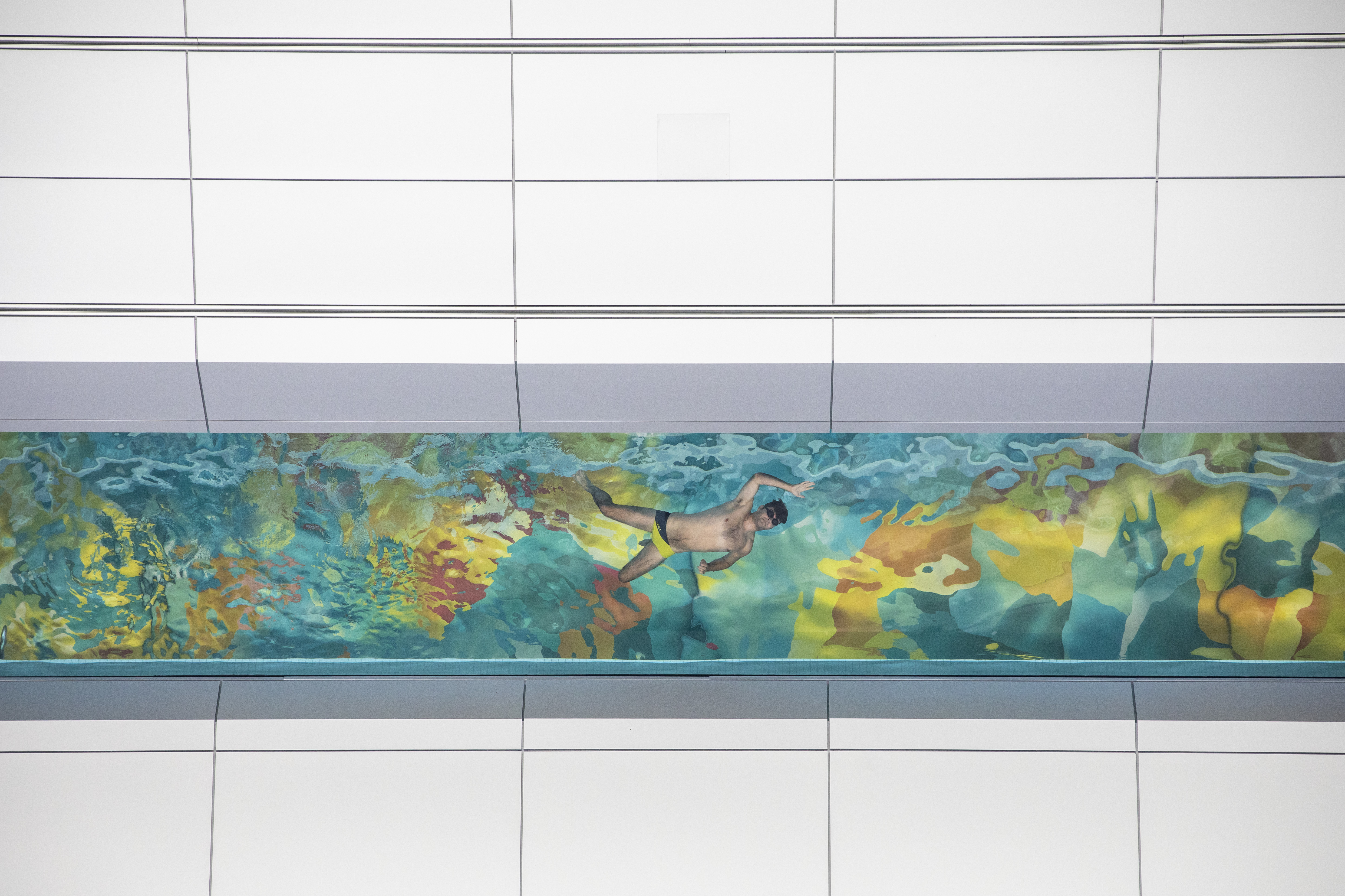 A swimmer in a clear acrylic glass bottom pool that is 60 metres above the ground in Concord Pacific’s new condo building The Arc in Vancouver, British Columbia on Aug. 15, 2019. (Ben Nelms/CBC)