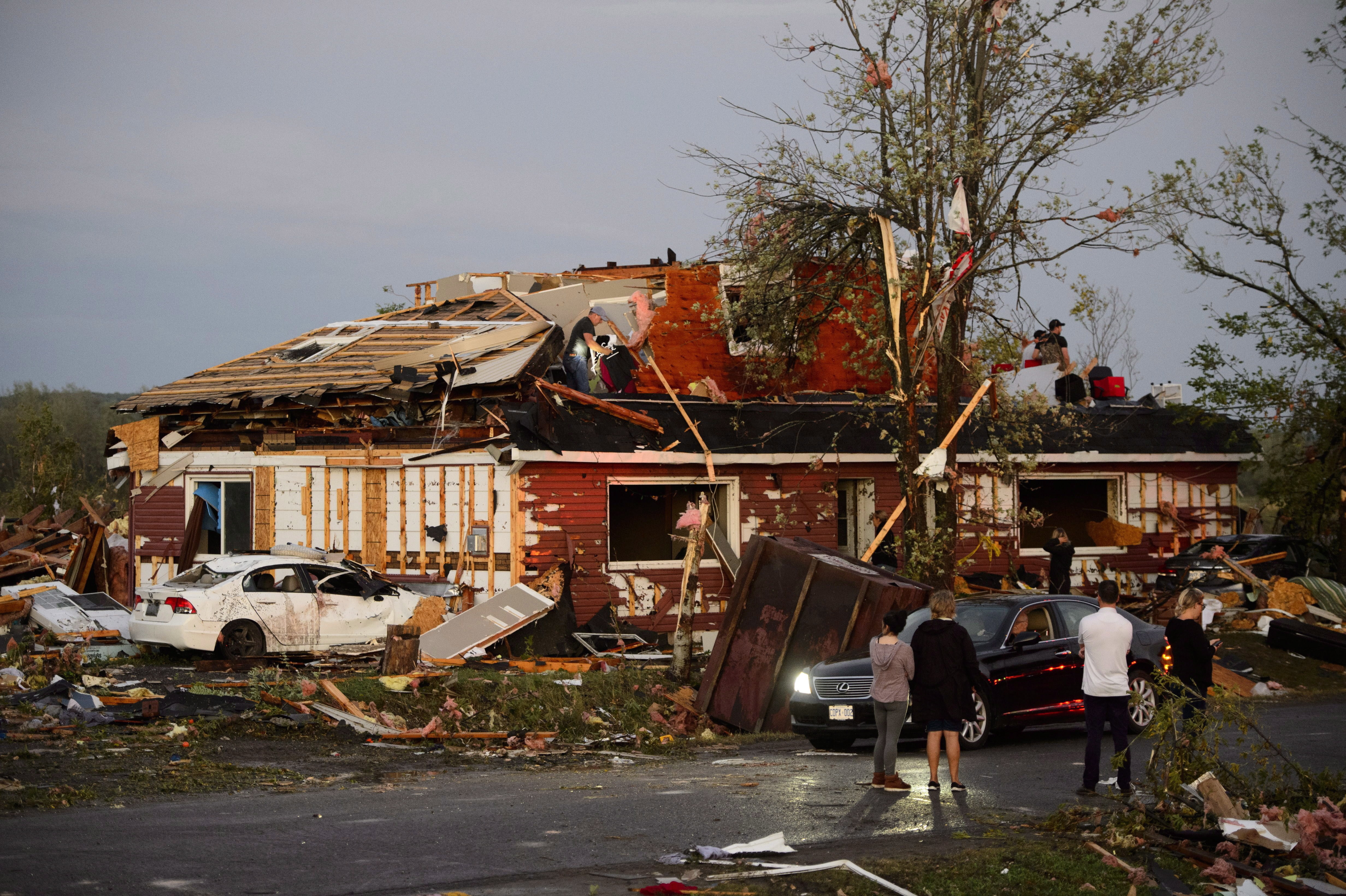 A group of people gather to inspect the damage caused by the tornado that hit Dunrobin. (Sean Kilpatrick/Canadian Press)