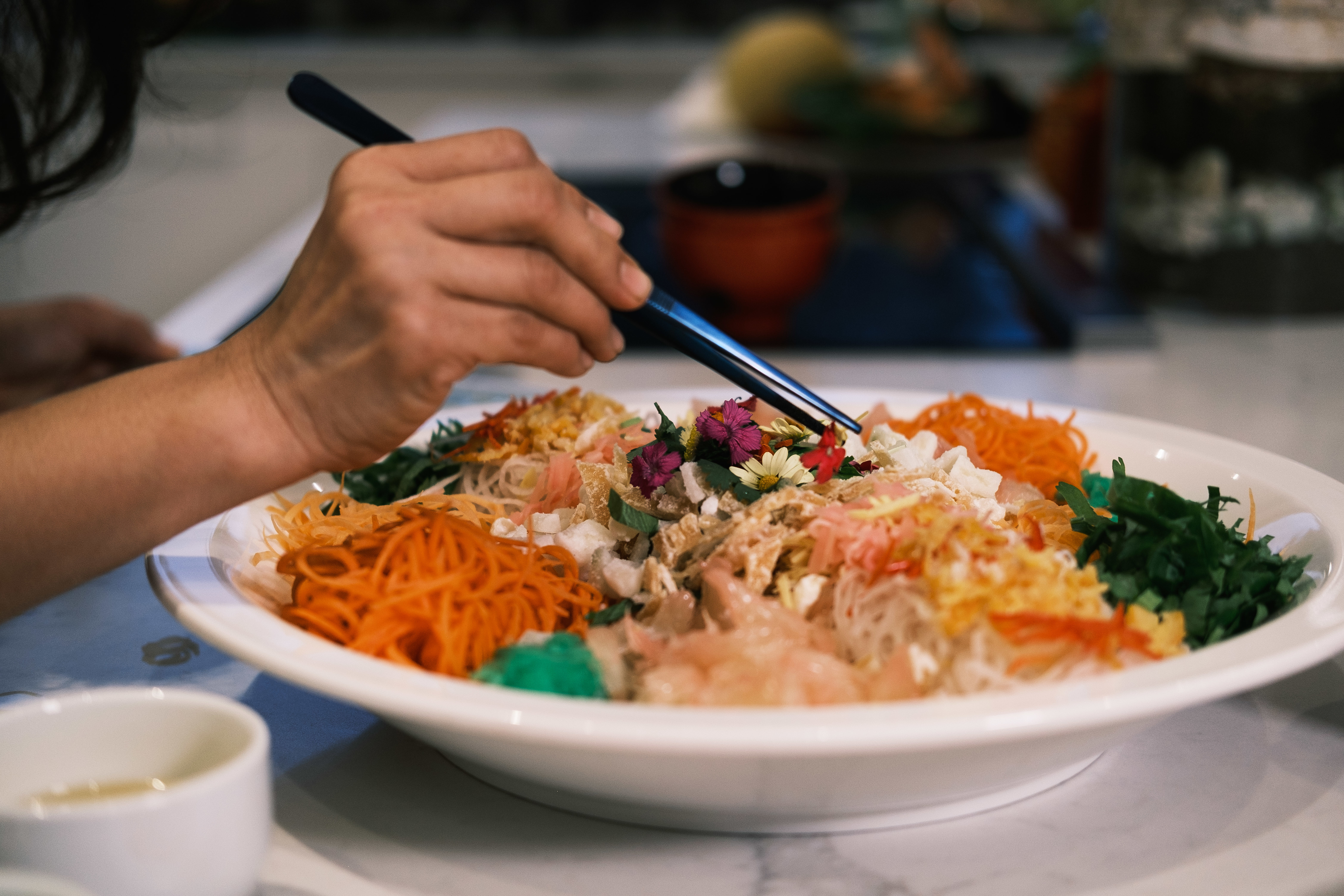 Each ingredient in yusheng, from the shredded vegetables to the oil, bears significance to the new year.