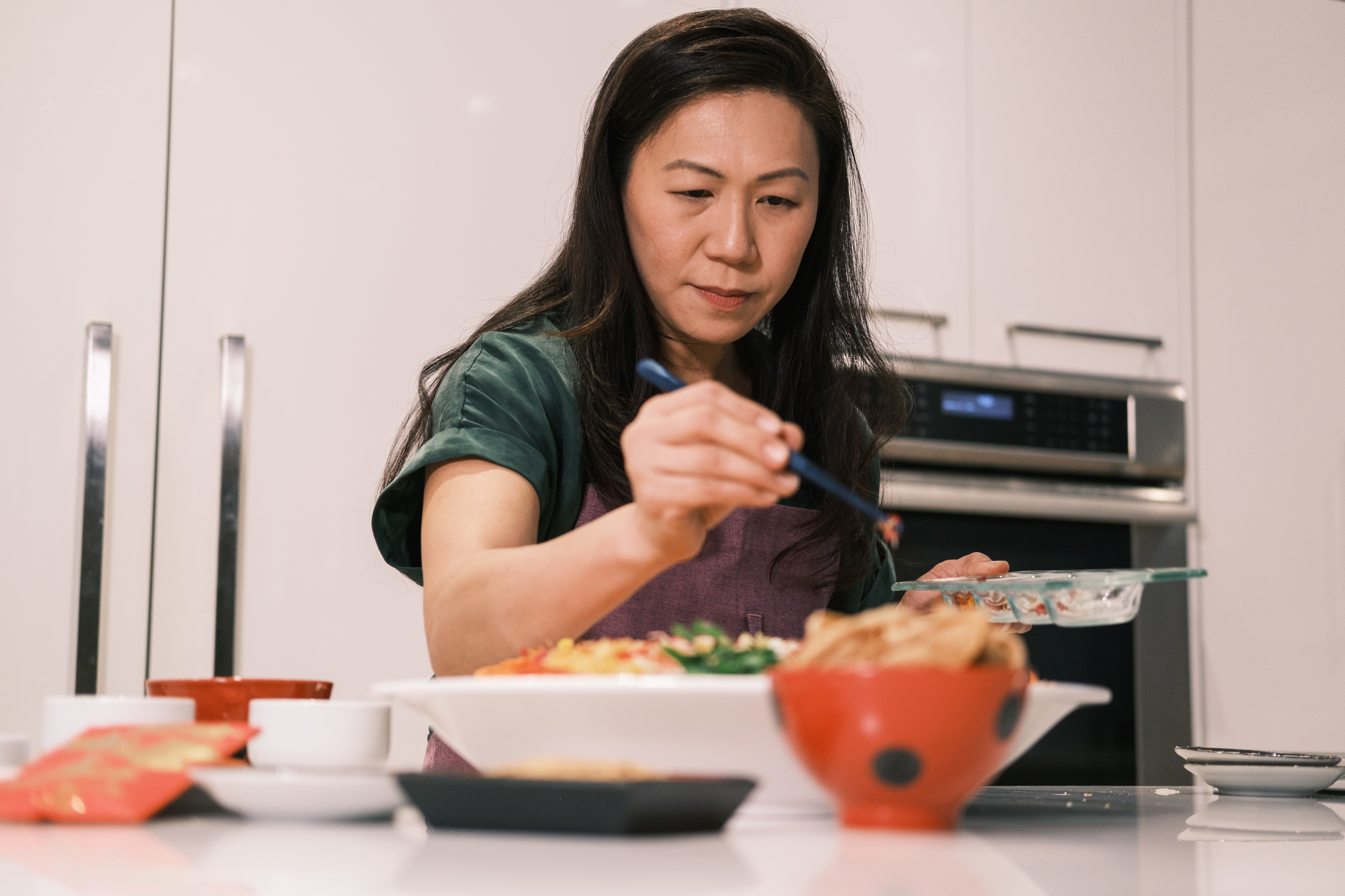 Regina Lee garnishes her yusheng with flower petals.