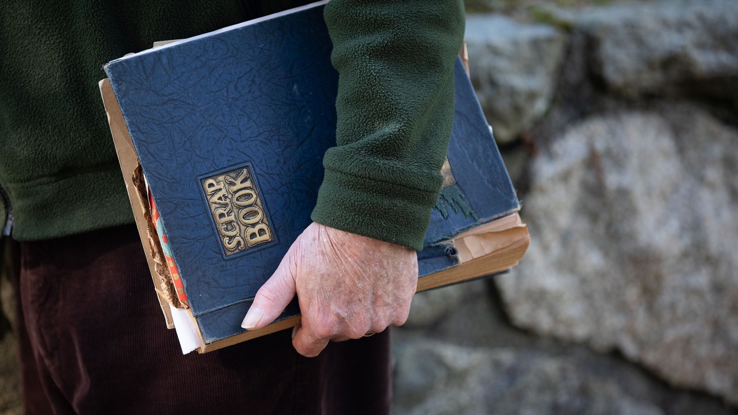 Don Robertson clutches a scrapbook with memories of his childhood inside. (Maggie MacPherson/CBC)