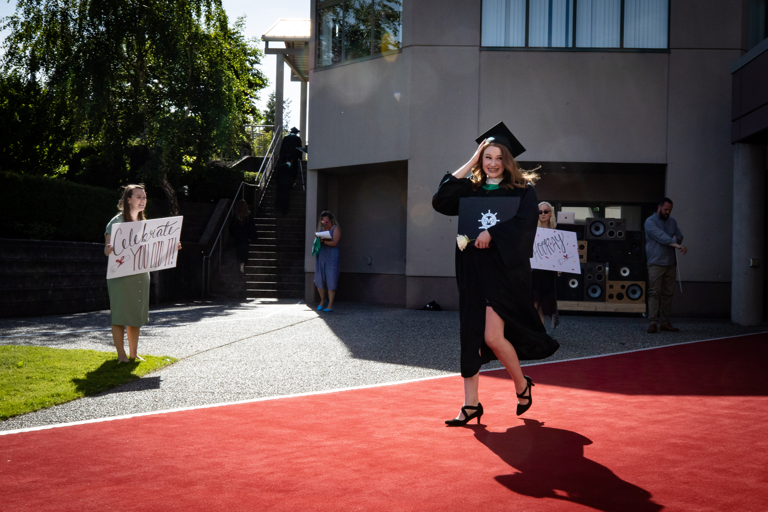 An Earl Marriott Secondary School graduate walks down a red carpet at a physically distanced graduation ceremony in Surrey on May 27, 2020. (Maggie MacPherson/CBC)