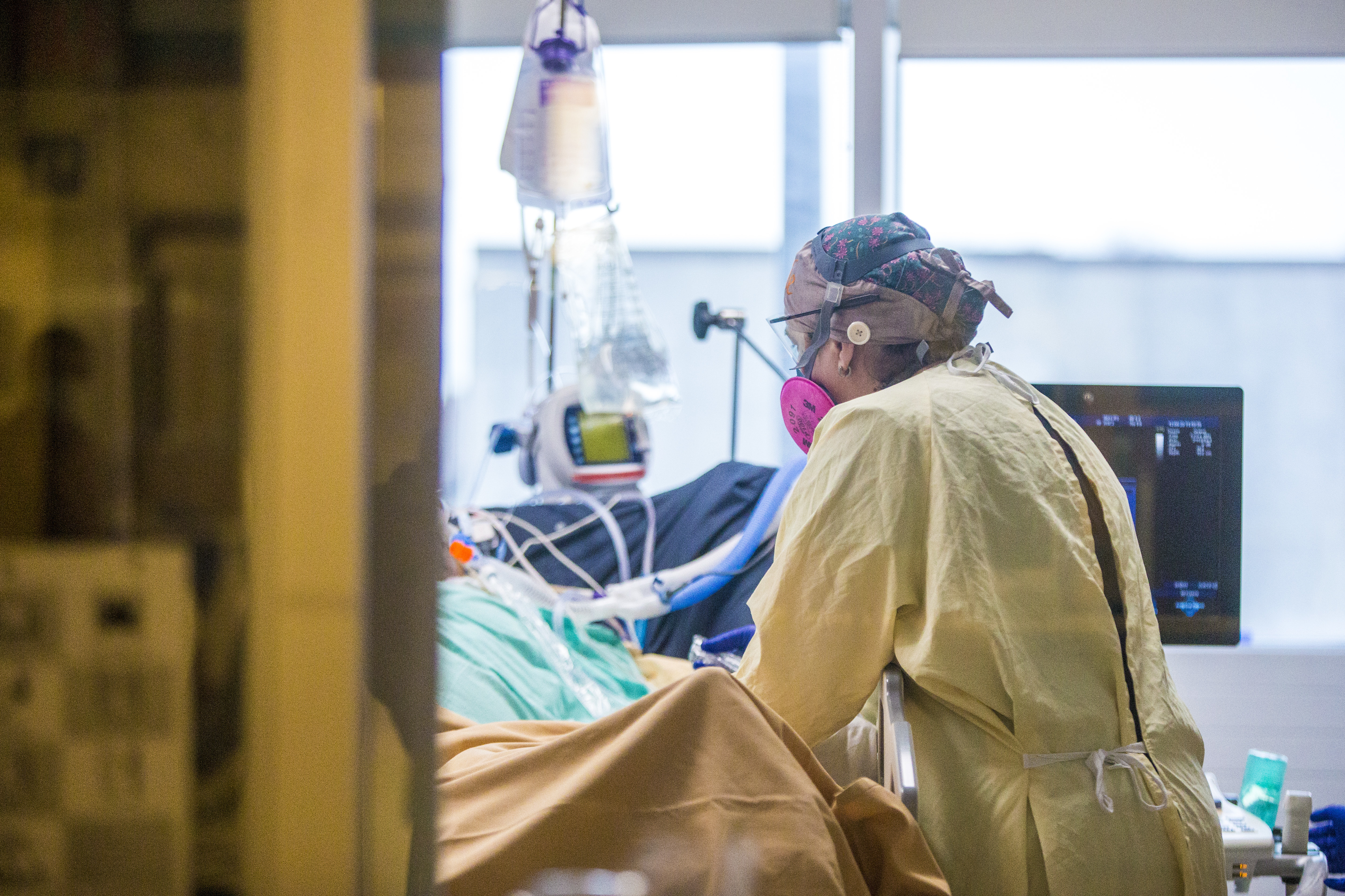 A health-care worker hovers over an intubated patient with COVID-19 in the medical intensive care unit at the Health Sciences Centre in Winnipeg. (Mikaela MacKenzie/Winnipeg Free Press/Canadian Press)