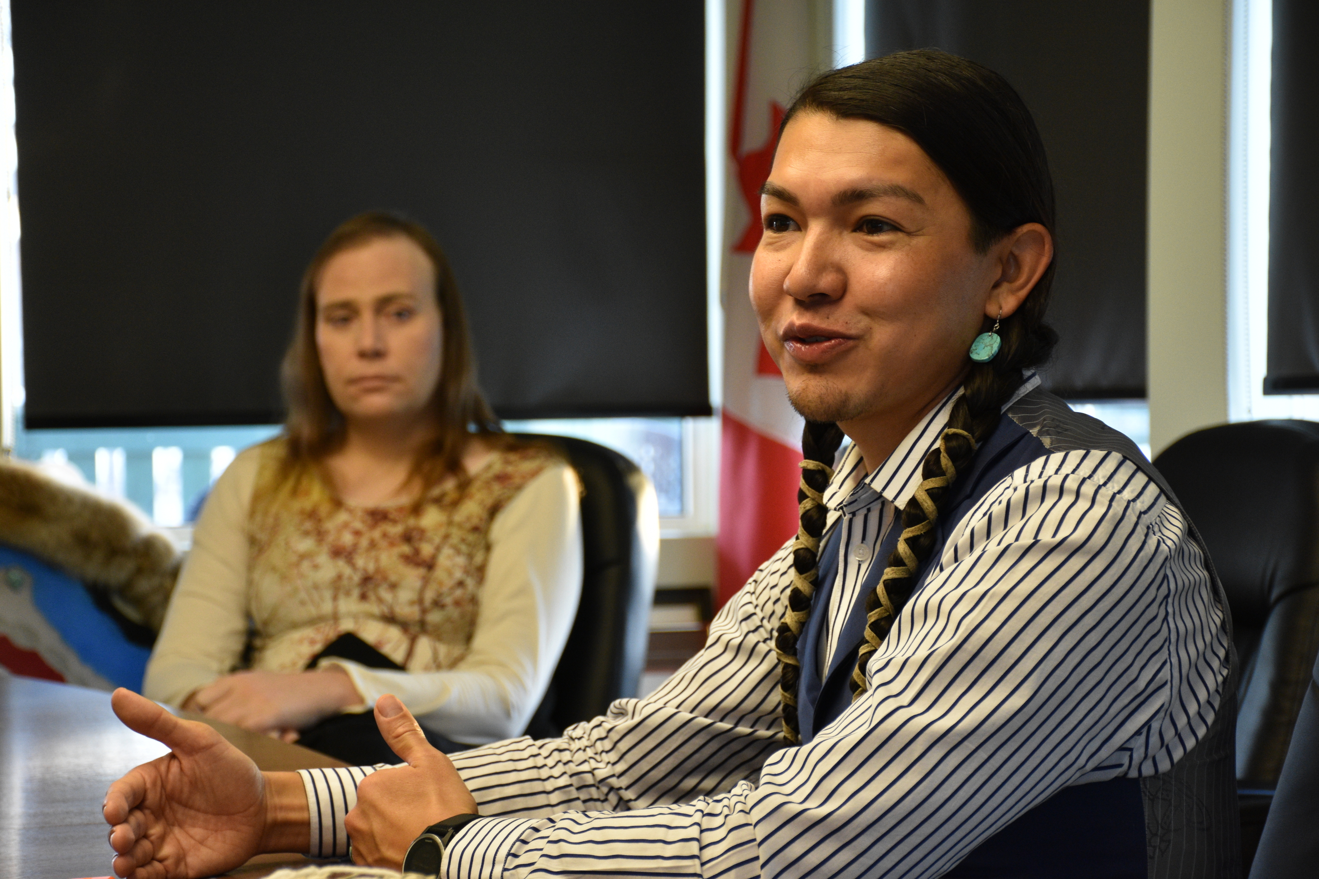 Dr. James Makokis discusses his work with the transgender community as one of his patients, Sarah Handy, looks on.(Terry Reith/CBC)