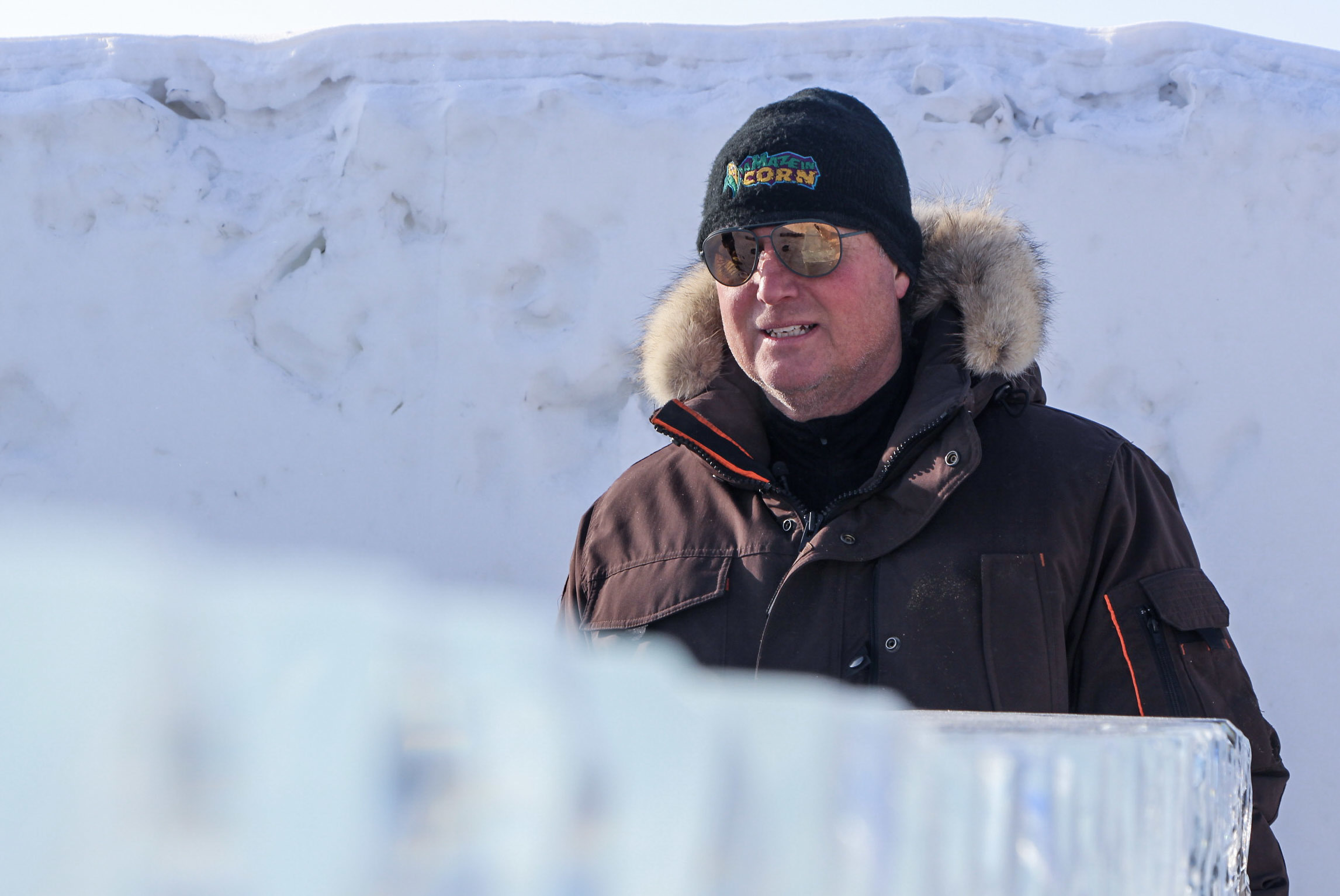 Clint Masse, co-owner of A Maze in Corn, stands over an ice sculpture in his snow maze. (Ahmar Khan/CBC)