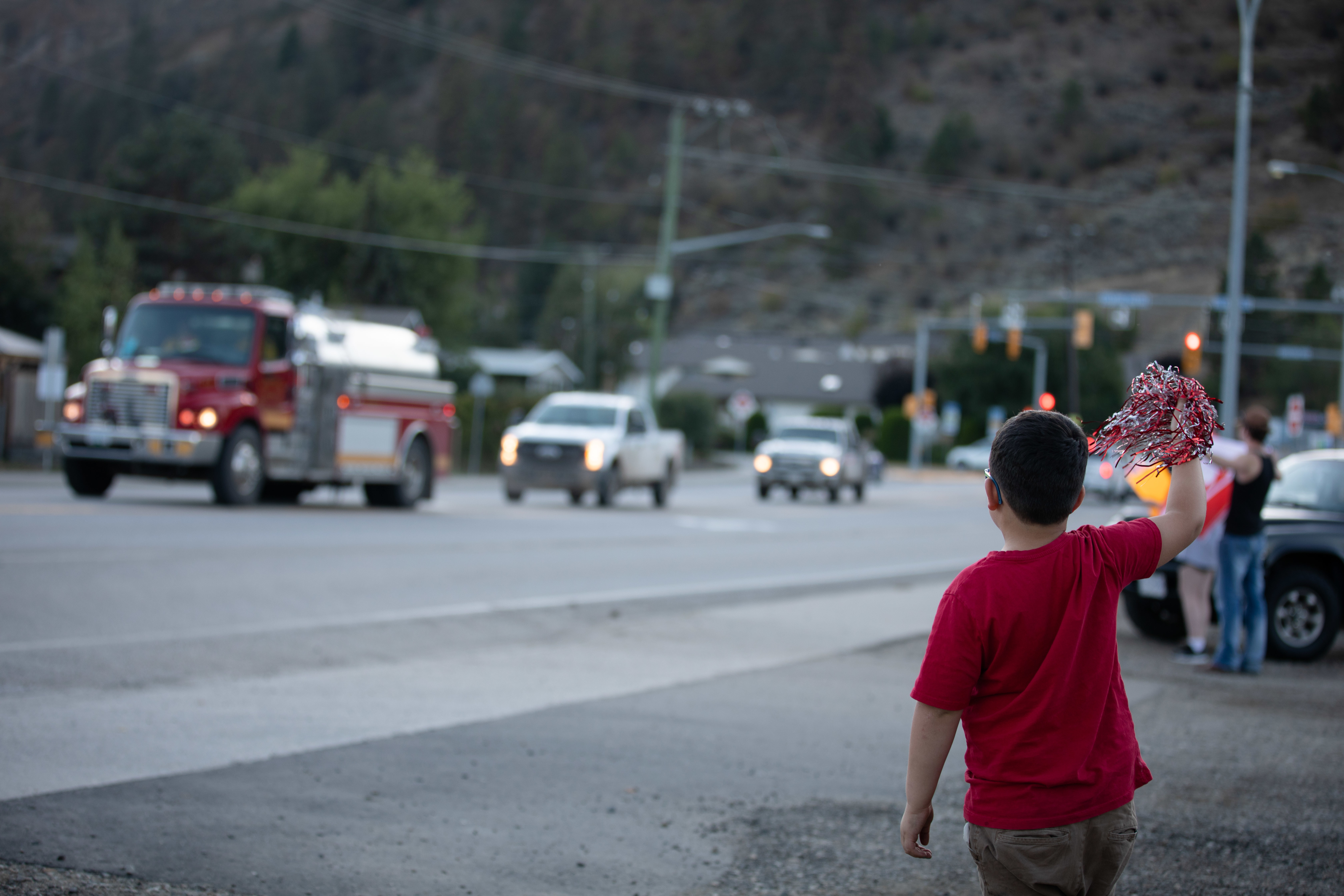 A young boy cheers firefighters as they return from their shifts in Vernon, B.C., on Sept. 2. (Maggie MacPherson/CBC)