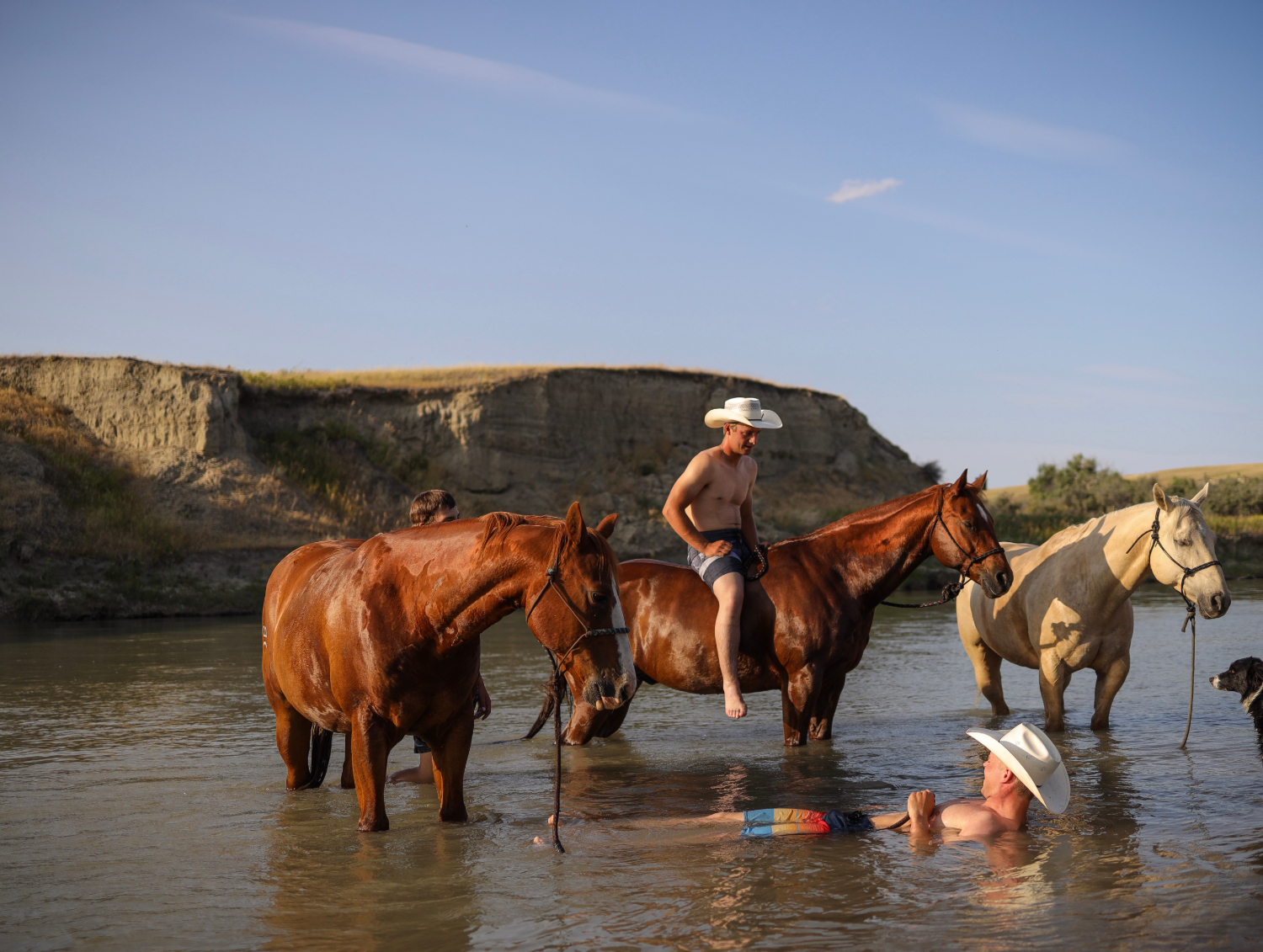 Ben Bamford, left, and Tate Mosby cool off in the Milk River before the start the rodeo.