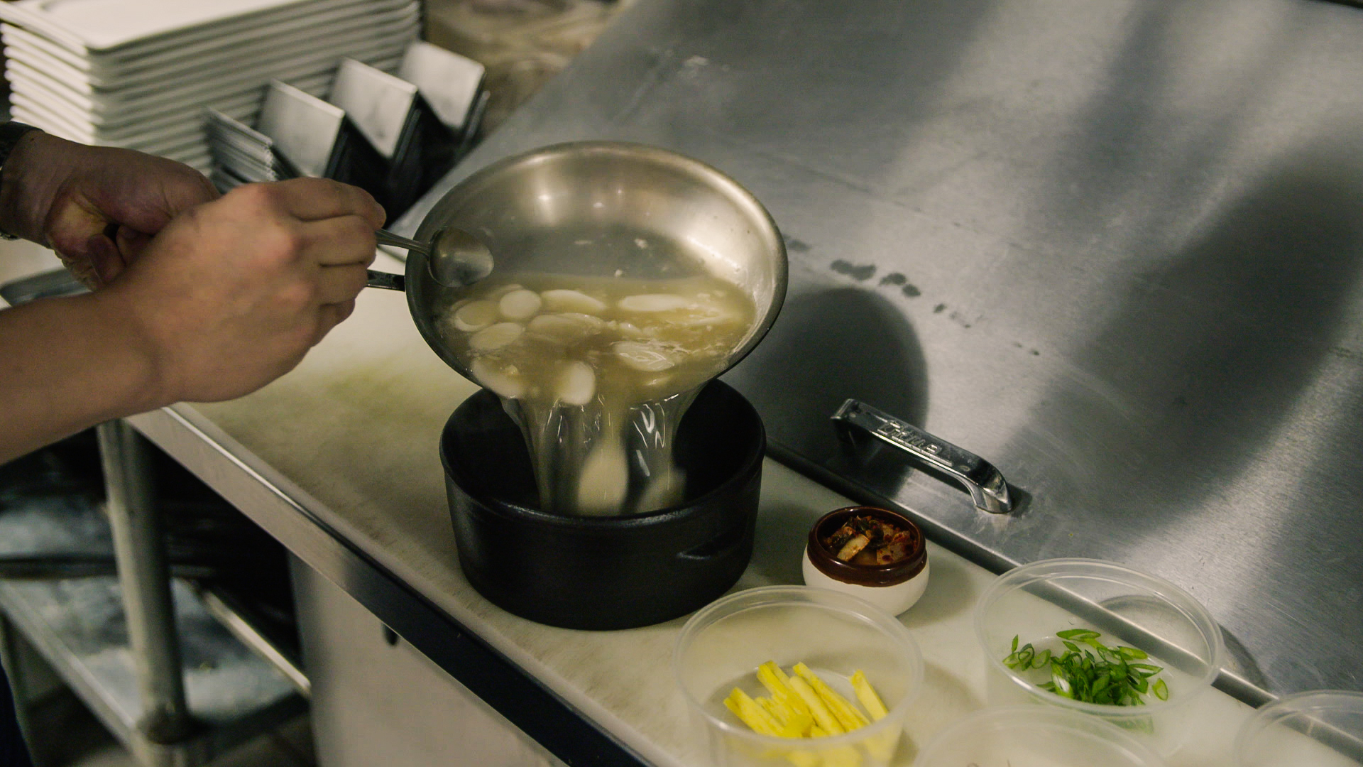 Eric Lee puts together a fresh pot of dduk guk in his kitchen.