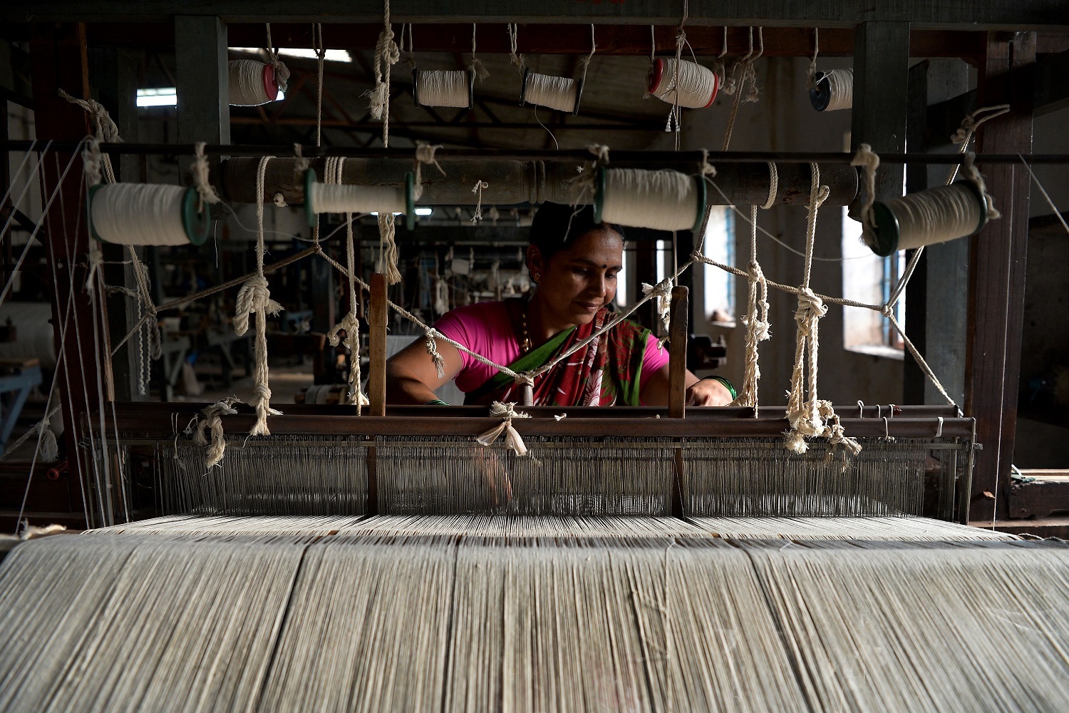 This photo taken on May 9, 2018 shows an employee of Khadi Gramodyog Samyukta Sangh weaving cotton yarn at Tulasigeri village in the southern Indian state of Karnataka. (Manjunath Kiran/AFP/Getty Images)