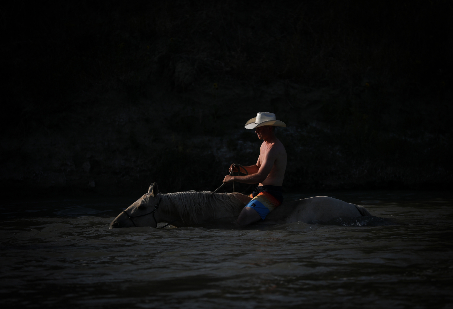 Tate Mosby rides his horse in the Milk River.