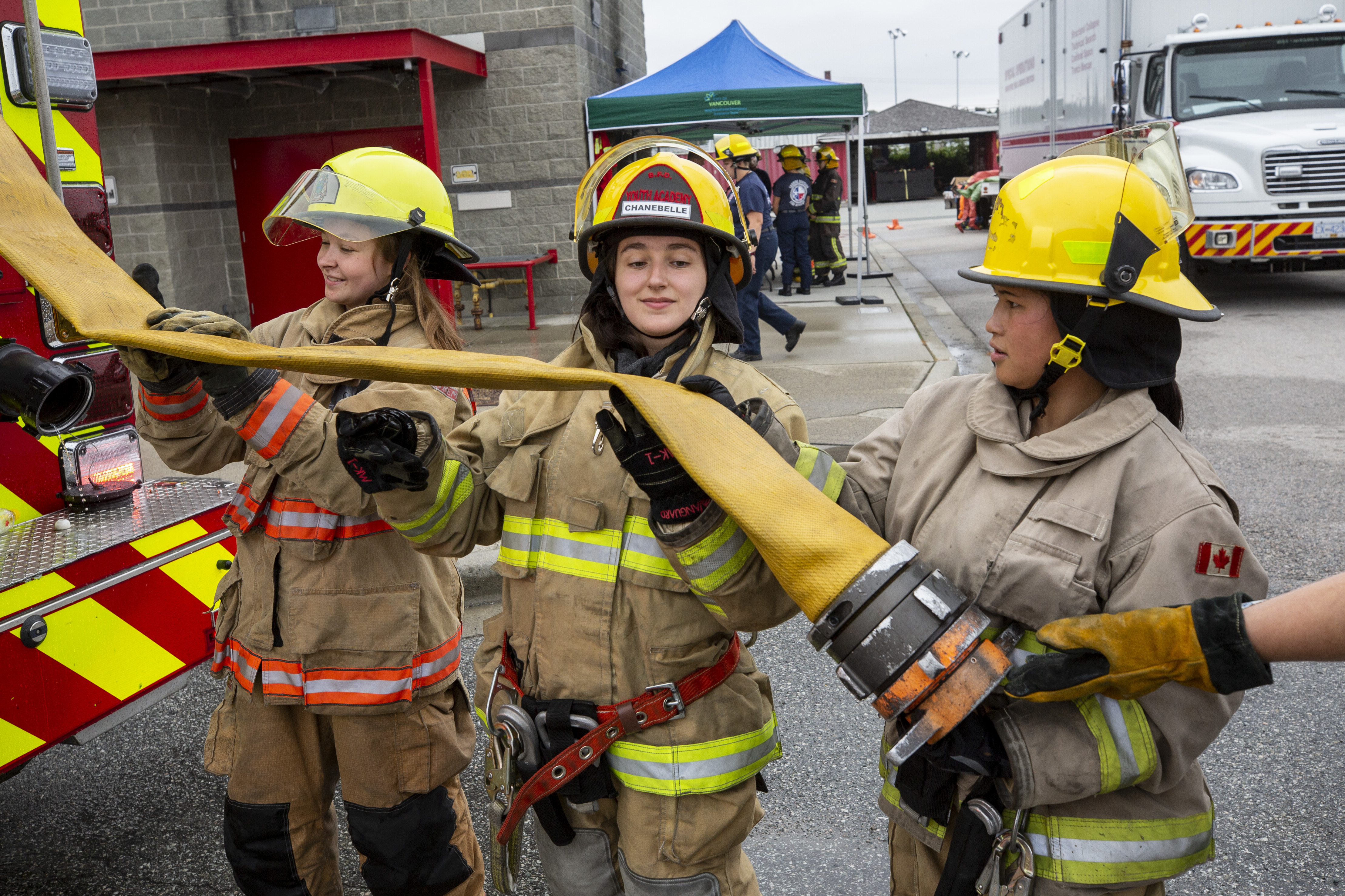 Chanebelle Murphy-Salazar helps put away a firehose onto a firetruck. She's one of more than 20 girls participating in Camp Ignite this week. (Ben Nelms/CBC)