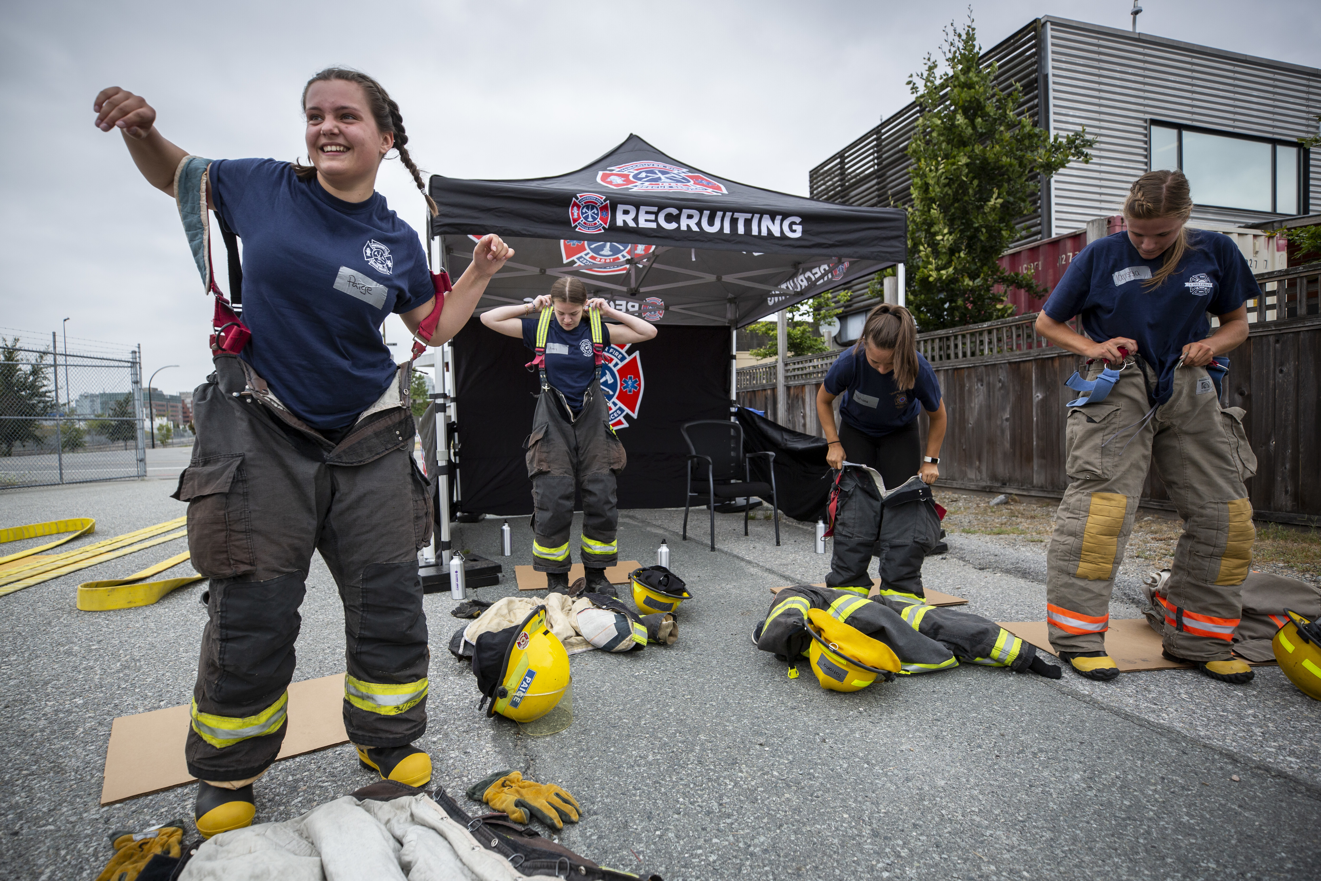 Girls at Camp Ignite put on their firefighting equipment before a training exercise. The gear is heavy, and most of them have never put it on before. (Ben Nelms/CBC)