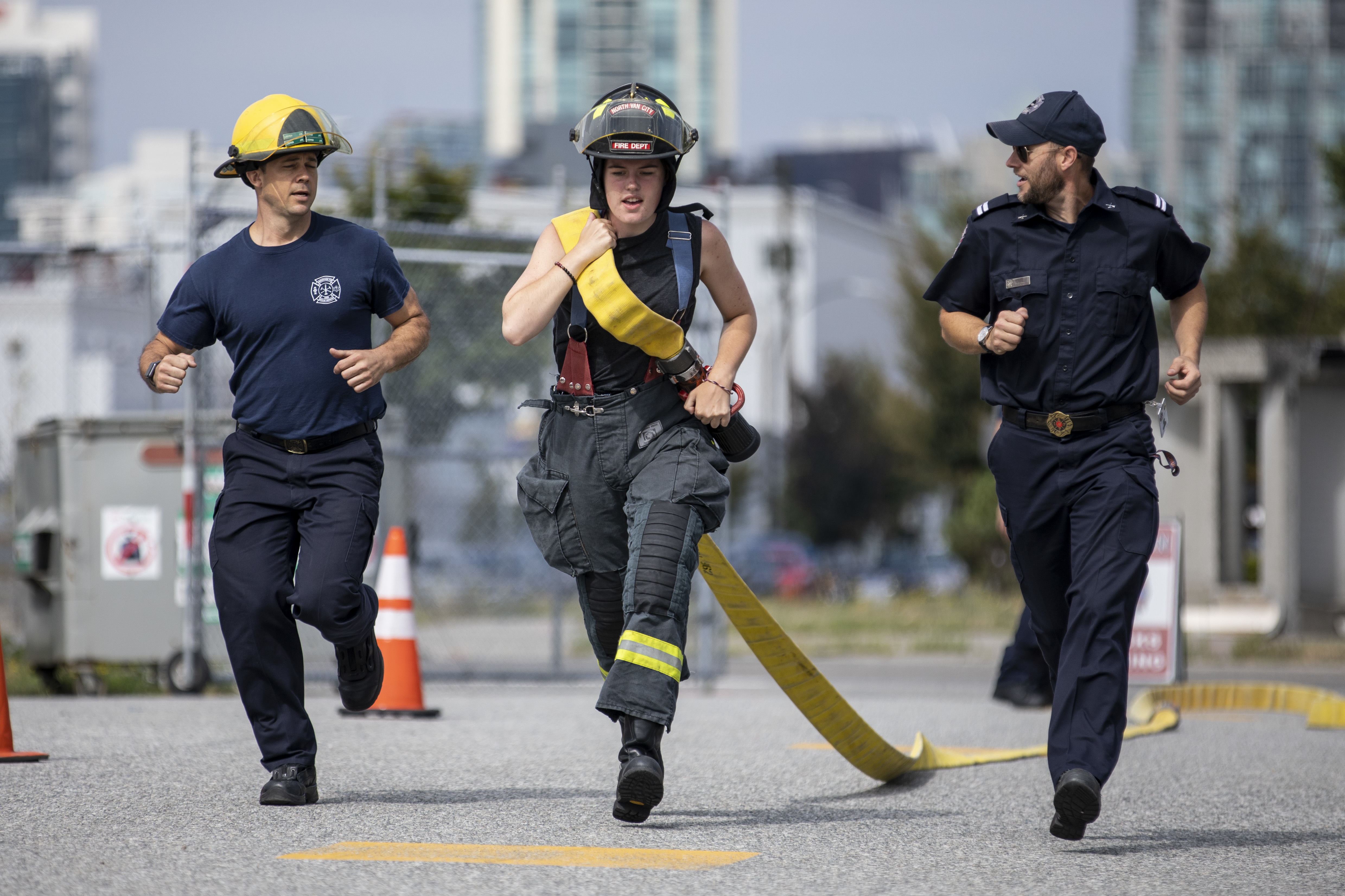 A Camp Ignite participant runs with a firehose as part of a training exercise for endurance and strength. (Ben Nelms/CBC)