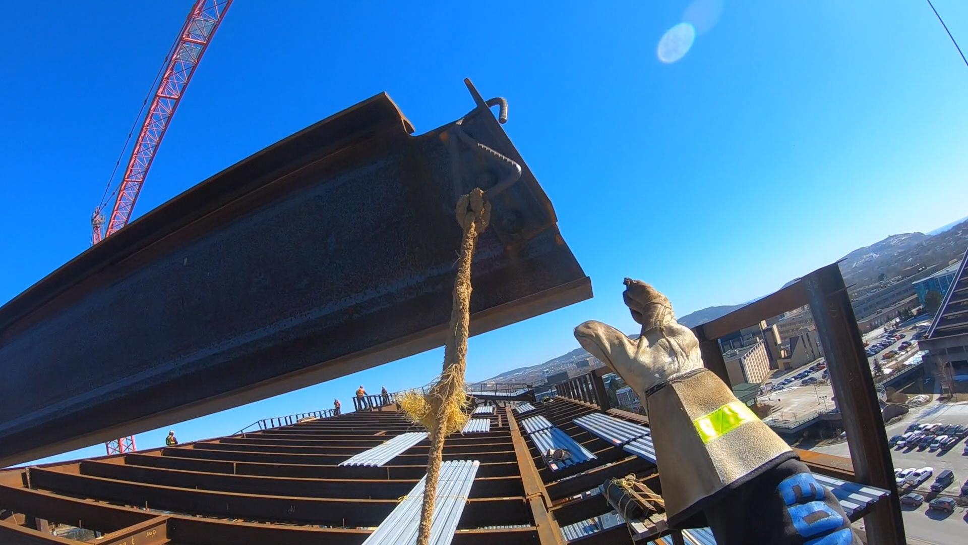 Gene Lewis reaches out to grab a steel beam. (CBC)