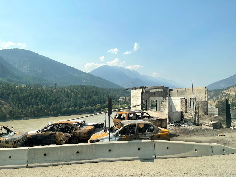 Burnt-out cars stand in front of a ruined building in Lytton, B.C., on July 9, 2021. (Bethany Lindsay/CBC News)