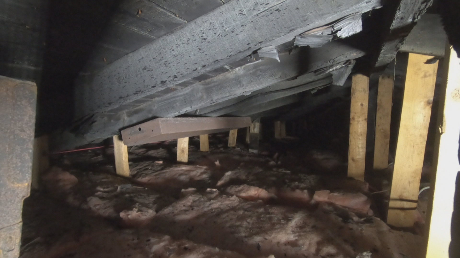 The walls and beams inside the attic of 11 Summer St. are charred black. Specks of burnt wood are present on the insulation inside the attic. (Paul Pickett/CBC)