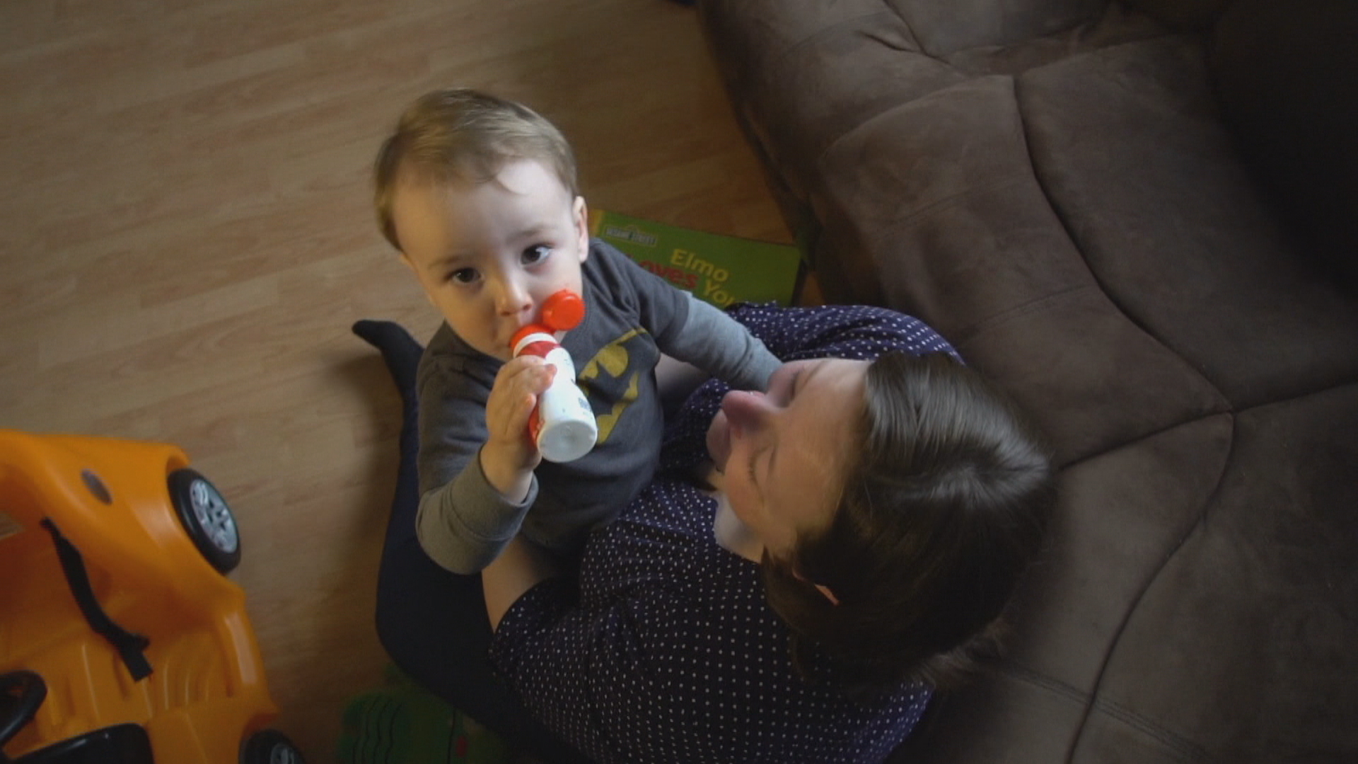 Henry sips on yogurt as he sits on his mom, Holly Gibson's lap, at their home in Mount Pearl. (Sherry Vivian/CBC)