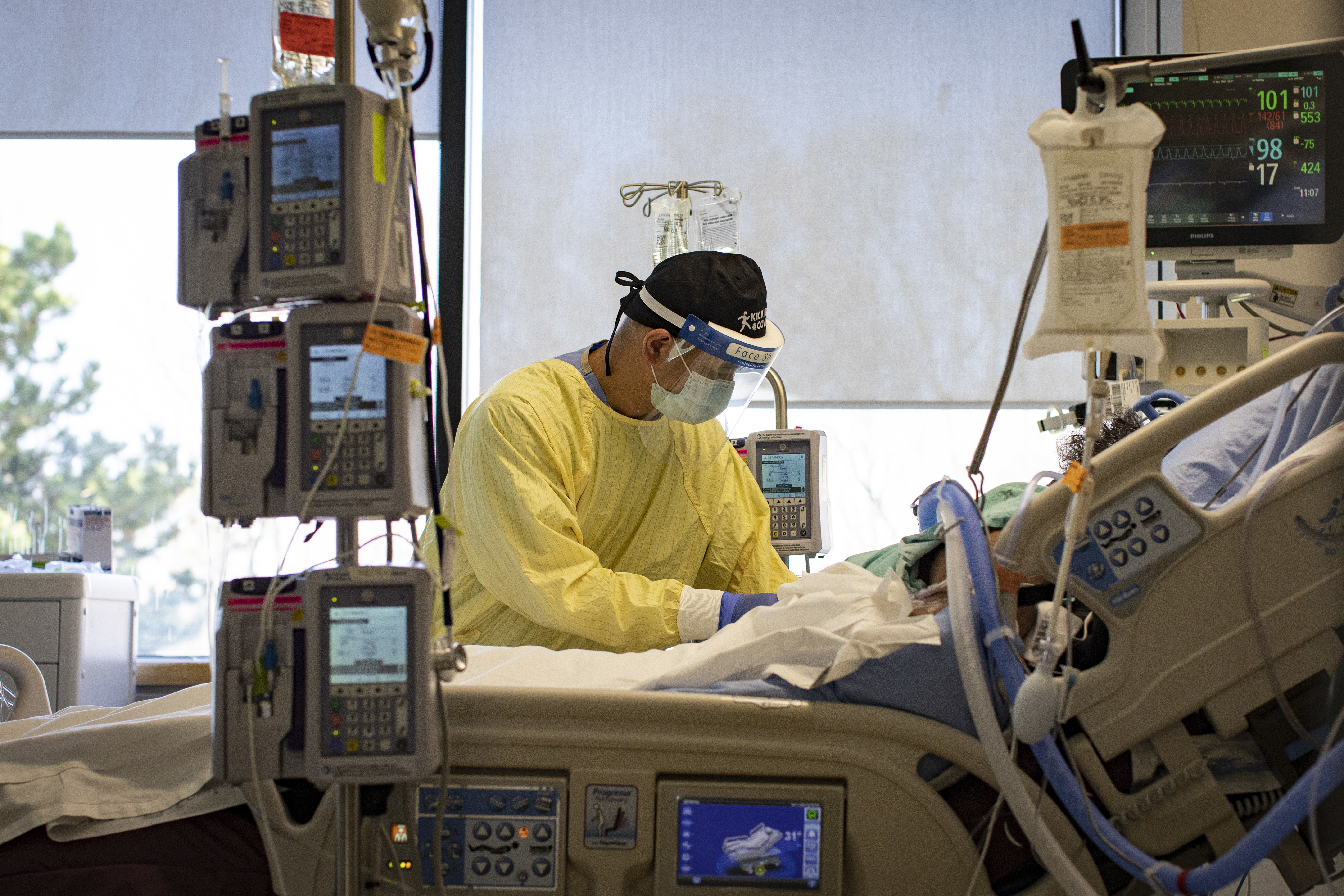 Registered nurse Jose Pasion cares for a patient in his 50s inside an isolation room in Centenary Hospital's intensive care unit. (Evan Mitsui/CBC)