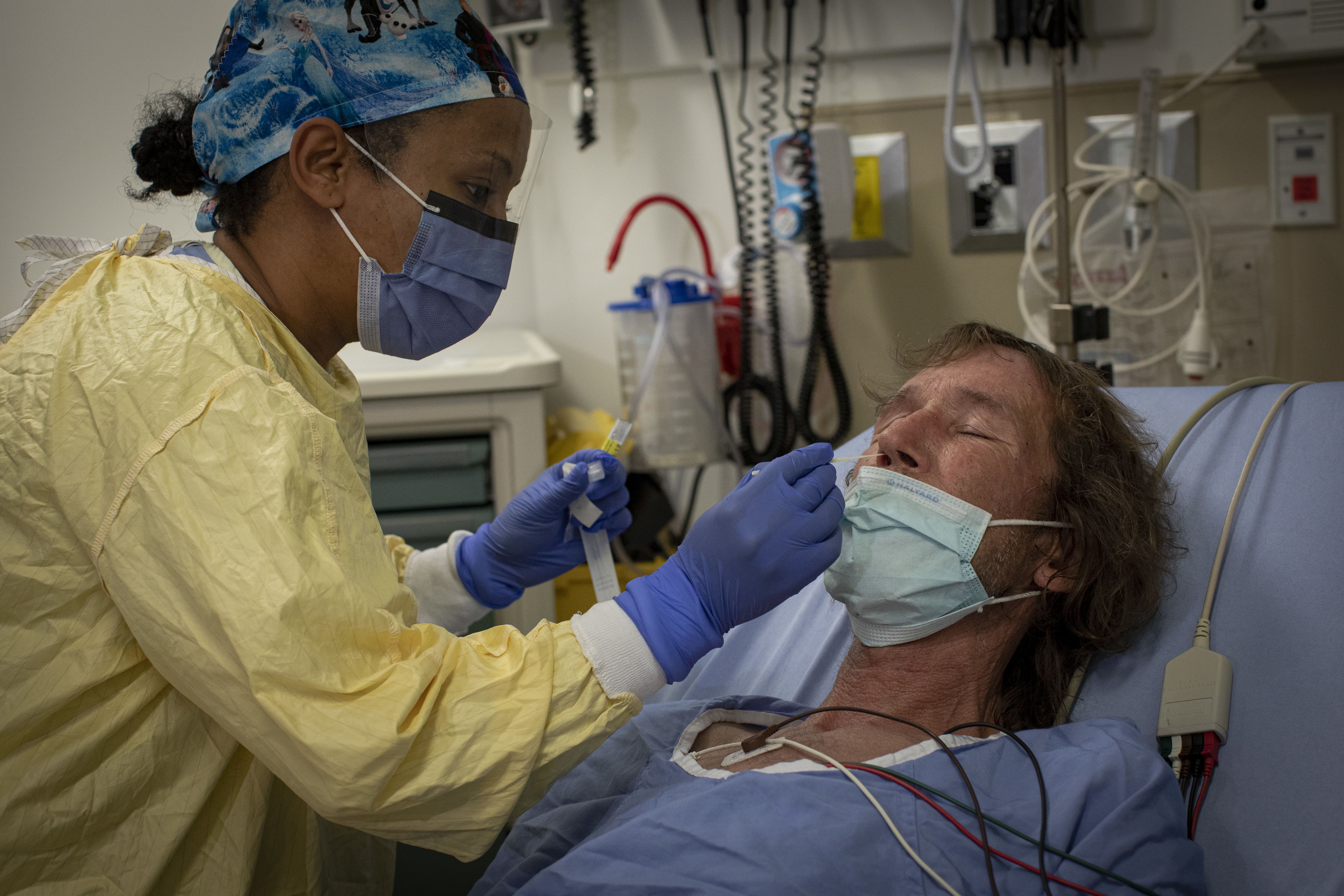 A health-care worker administers a COVID-19 swab test on 56-year-old Rick Furchner, who's in the Scarborough General emergency department because of pain caused by a blood clot. (Evan Mitsui/CBC)