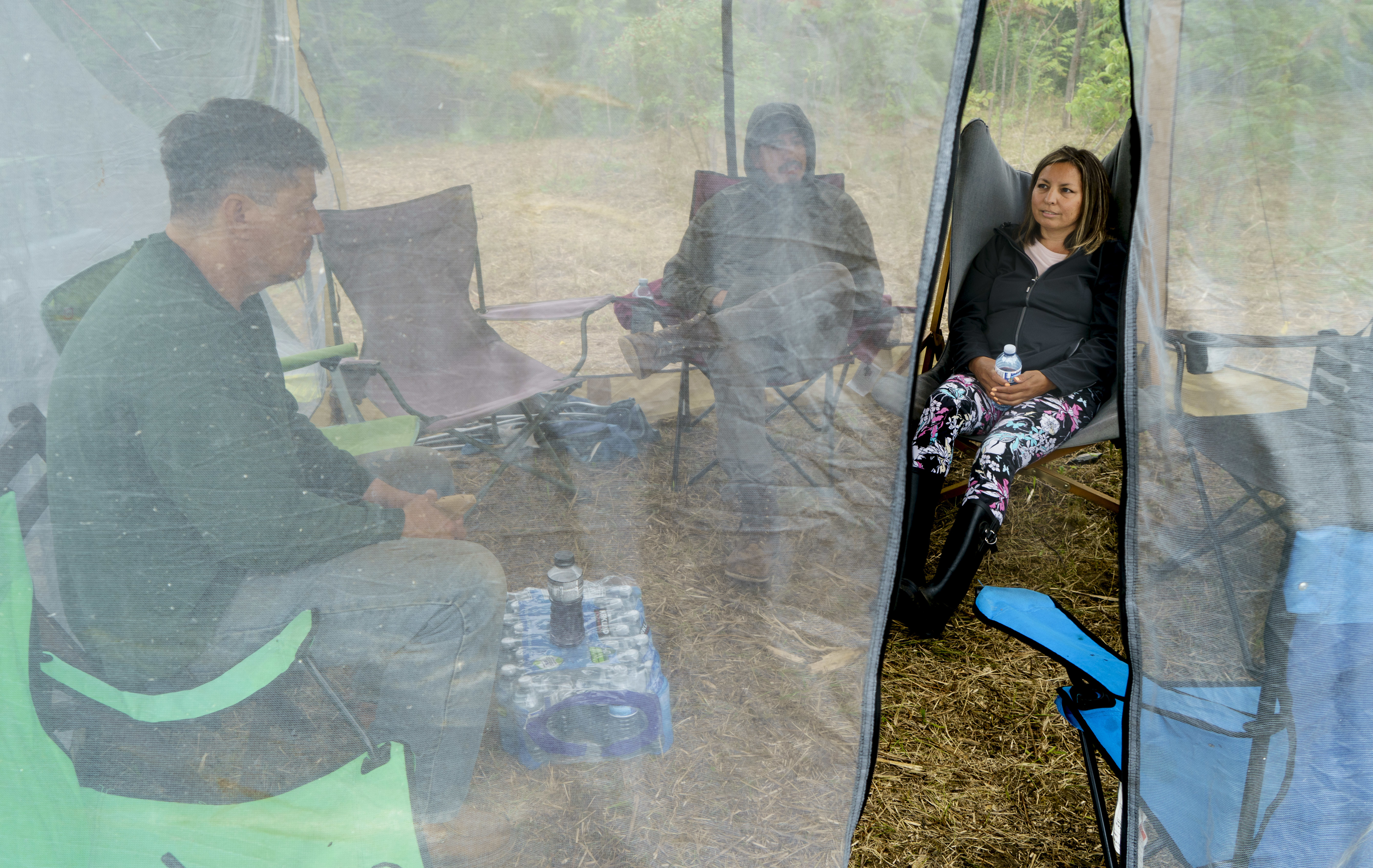 Karihwakatste Deer sits in a tent with fellow community members in a camp in Kahnawake on July 8. (Paul Chiasson/Canadian Press)