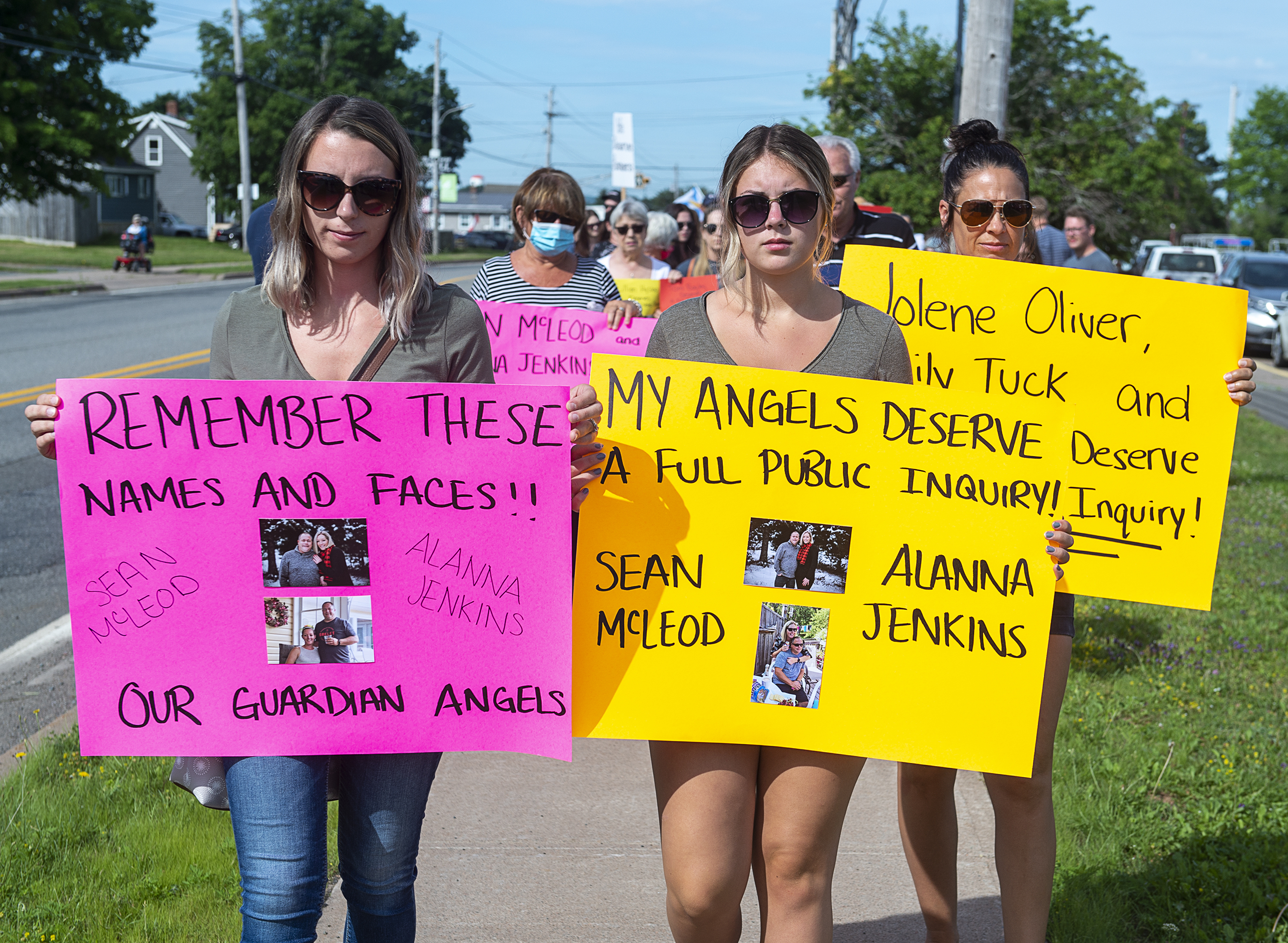 Family and friends of victims, including Sean McLeod's daughters, Taylor Andrews, left, and Amielia McLeod, attend a march demanding an inquiry into the April mass shooting in Nova Scotia that killed 22 people, in Bible Hill, N.S., on July 22, 2020. (Andrew Vaughan/The Canadian Press)