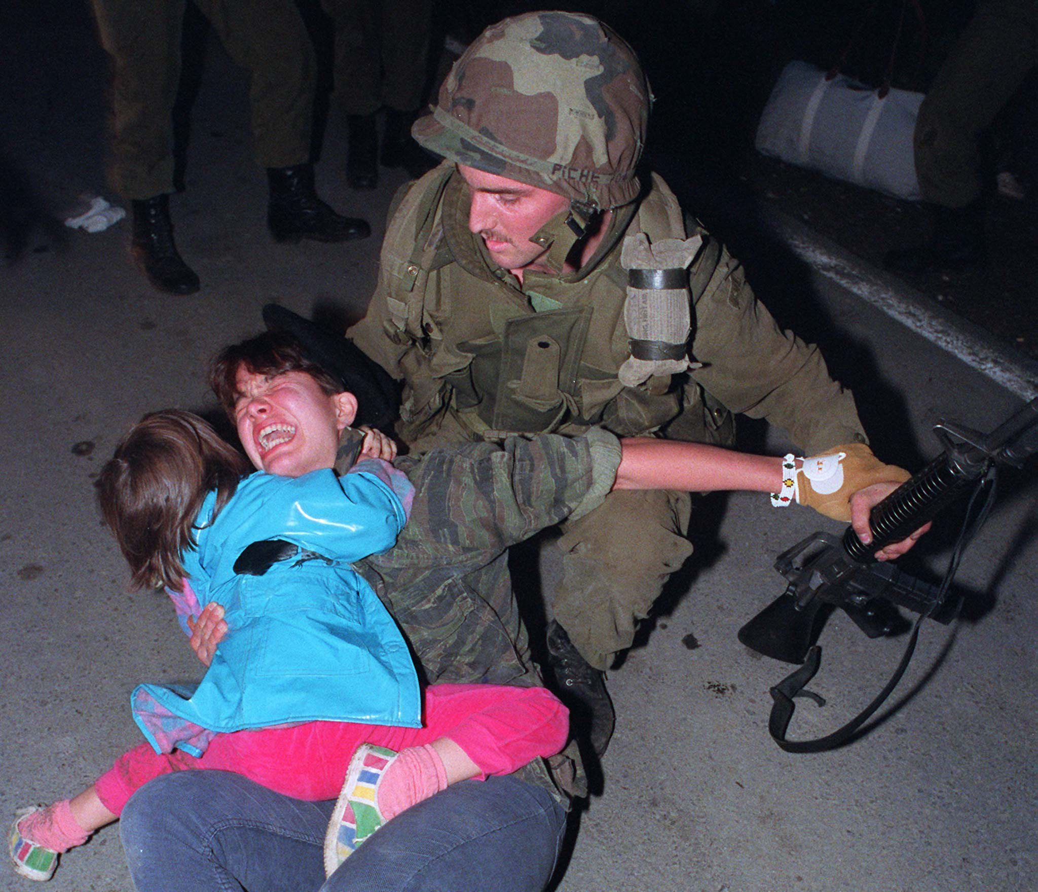 Waneek Horn-Miller clutches her younger sister Kaniehtiio Horn in one arm and a soldier's wrist in the other hand as she lies on Highway 344 in Kanesatake, Que., during the Oka Crisis. (Ryan Remiorz/Canadian Press)