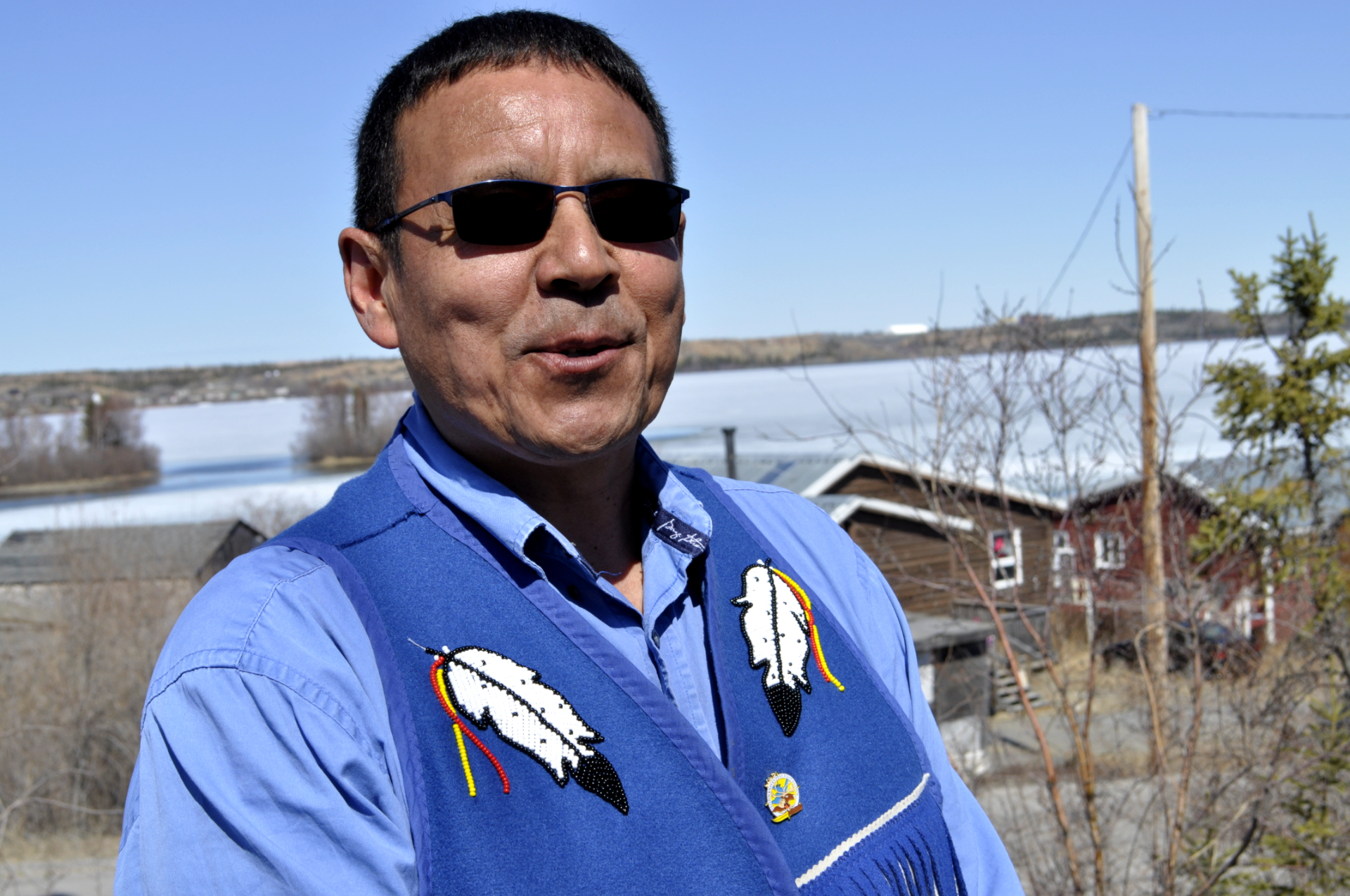 Yellowknives Dene Chief Ernest Betsina in Ndilo, N.W.T. Behind him is Giant Mine, a visible reminder of the worst-case scenario when a mining company collapses. (Alex Brockman/CBC)