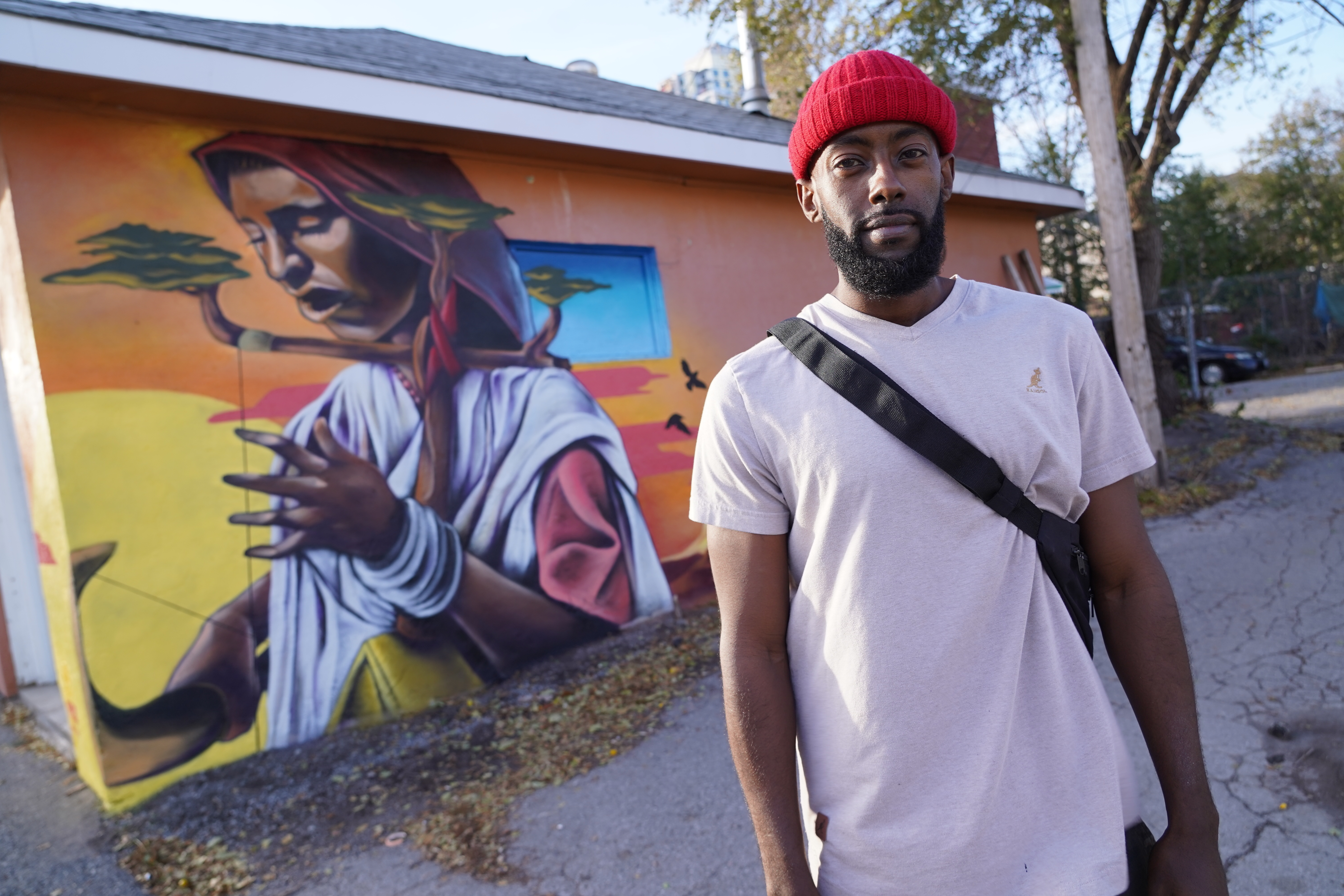 Kalkidan Assefa stands outside his new mural in Mechanicsville, which pays tribute to his Ethiopian heritage.(Simon Gohier/CBC)
