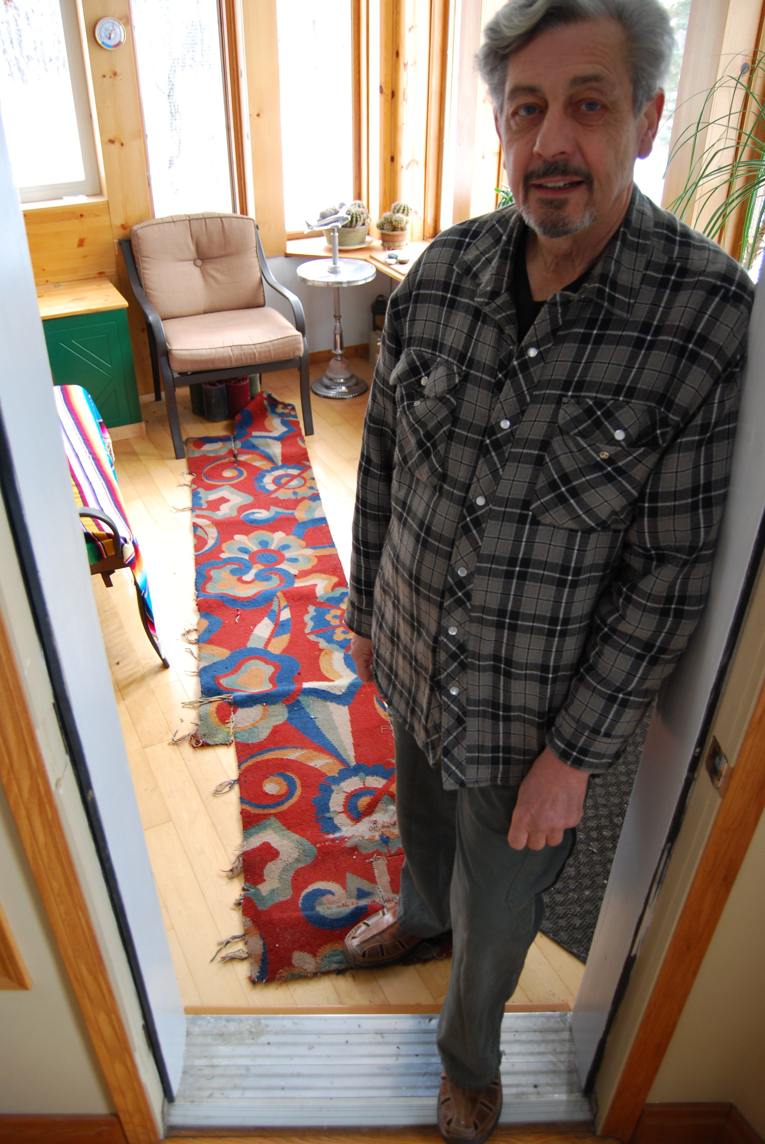 Saskatoon-area resident Richard Perry, pictured here in 2019, with a piece of Capitol carpeting he salvaged during the demolition of 1979. (Guy Quenneville/CBC) 