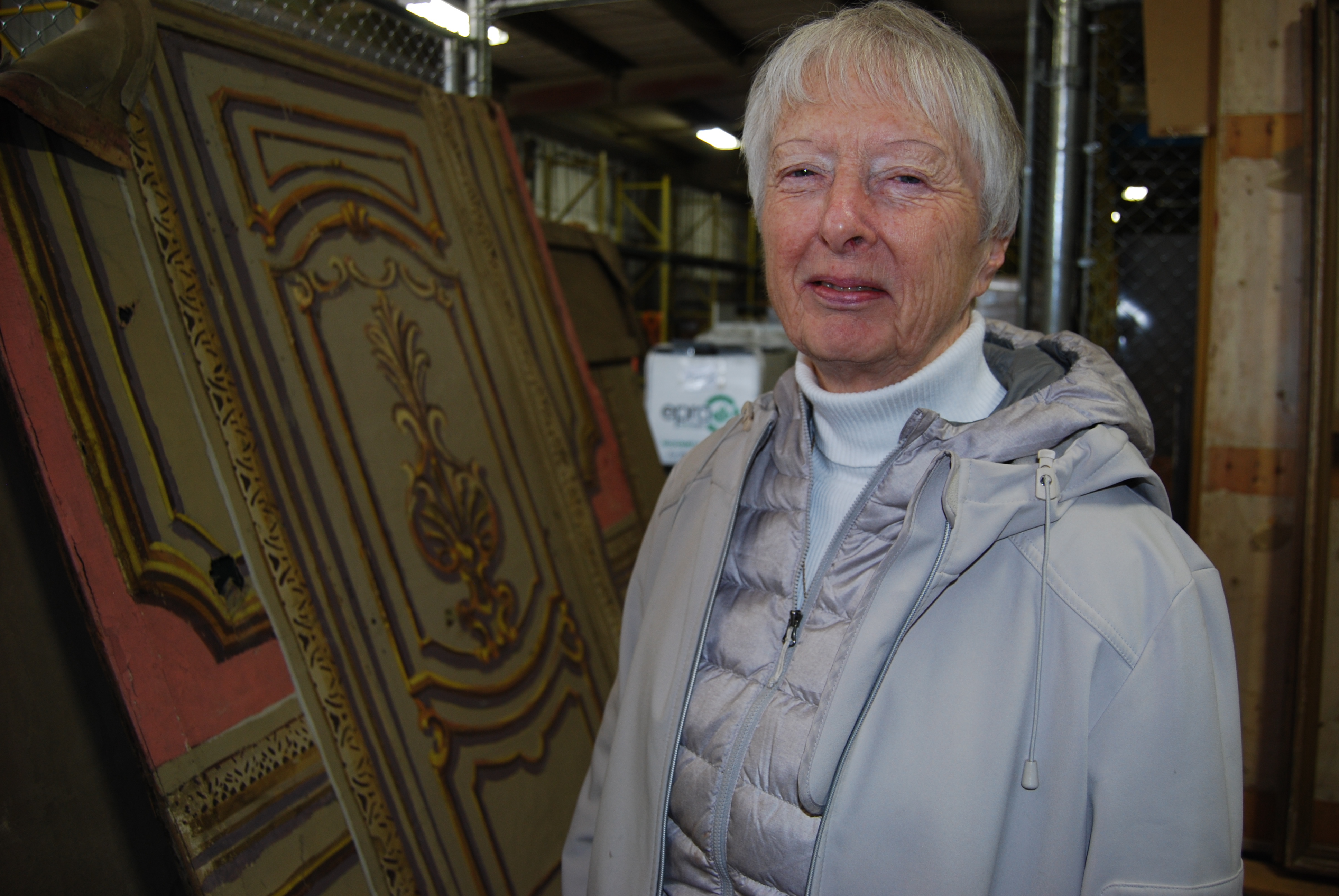 Peggy Sarjeant, the president of the Saskatoon Heritage Society, stands inside the city warehouse where dozens of Capitol relics continue to be stored. She'd like all the artifacts, including those secretly salvaged by people during the demolition, to be on display in a public space. (Guy Quenneville/CBC)