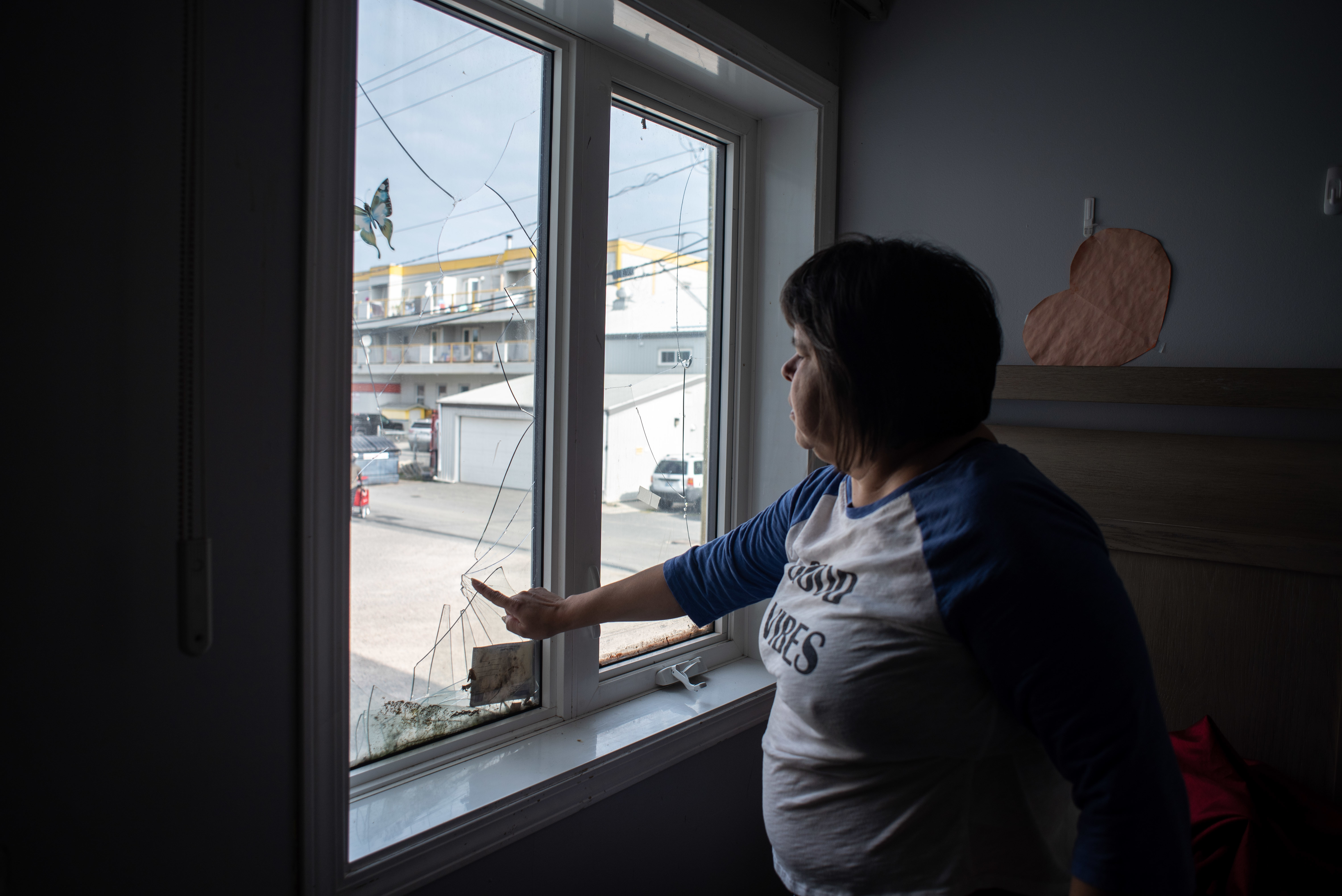 Verna Beaulieu points to the broken window in her apartment in Yellowknife. Beaulieu lives in Dorset Apartments in Yellowknife, which is owned by Northview Canadian High Yield Residential Fund. (Walter Strong/CBC)