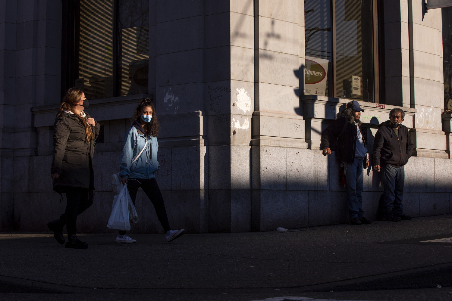 People wearing face masks walk near Main and Hastings streets in the Downtown Eastside neighbourhood of Vancouver on Dec. 4, 2020. (Ben Nelms/CBC Vancouver)