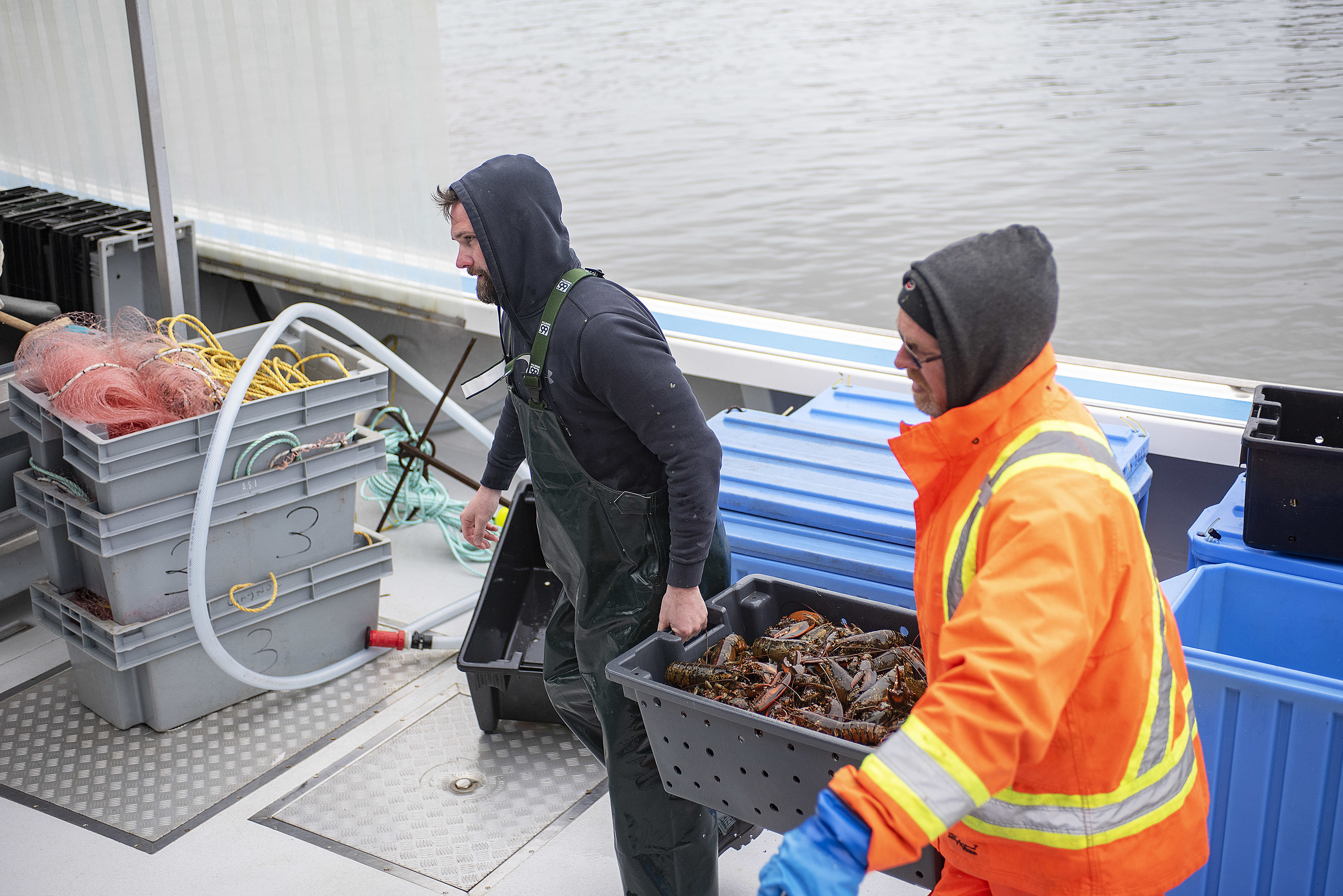 Scott McAleese, left, and Andy MacLeod, of Island Morning unload their cargo. The captain is Earl MacLeod. (Brian McInnis)