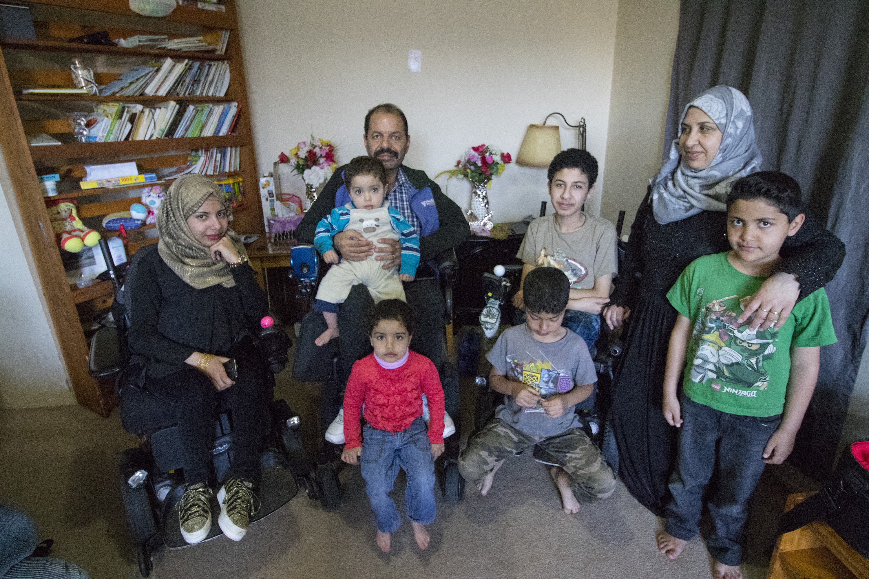 Eight members of the Harb family together in their living room. (Dave Irish/CBC)