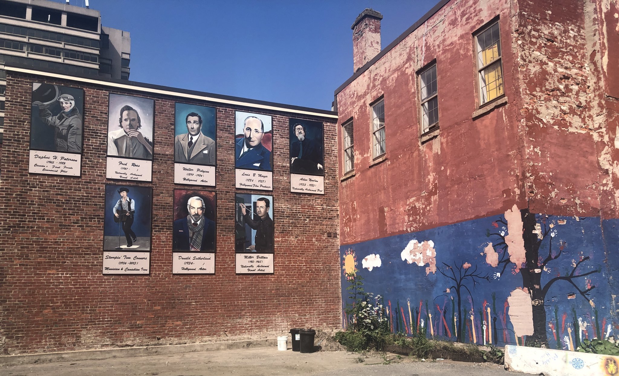 The wall of famous Saint John residents features poet Alden Nowlan, pilot Daphne H. Patterson, visual artist Fred Ross, film producer Louis B. Mayer, actors Walter Pidgeon and Donald Sutherland, musician Stompin’ Tom Connors and painter Miller Brittain but no people of colour. The portraits were painted by Grand Manan artist Sarah Griffin. (Julia Wright/CBC)