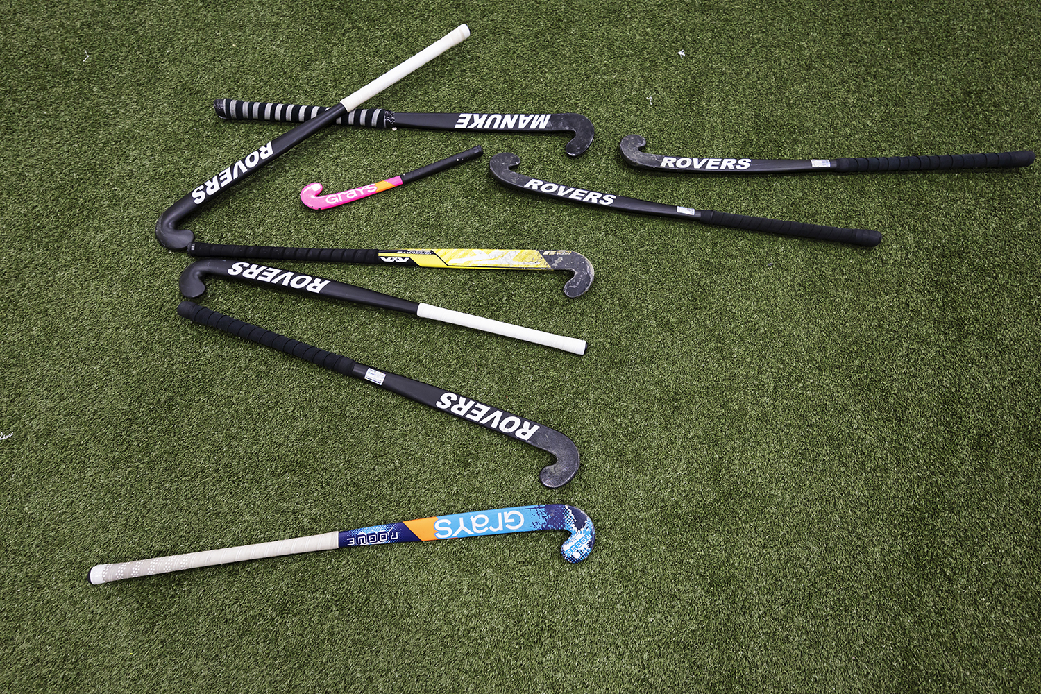 A field hockey stick collection is laid out on the turf. The Rovers import a majority of its equipment from Pakistan. The country is one of the largest manufacturers of field hockey equipment worldwide.