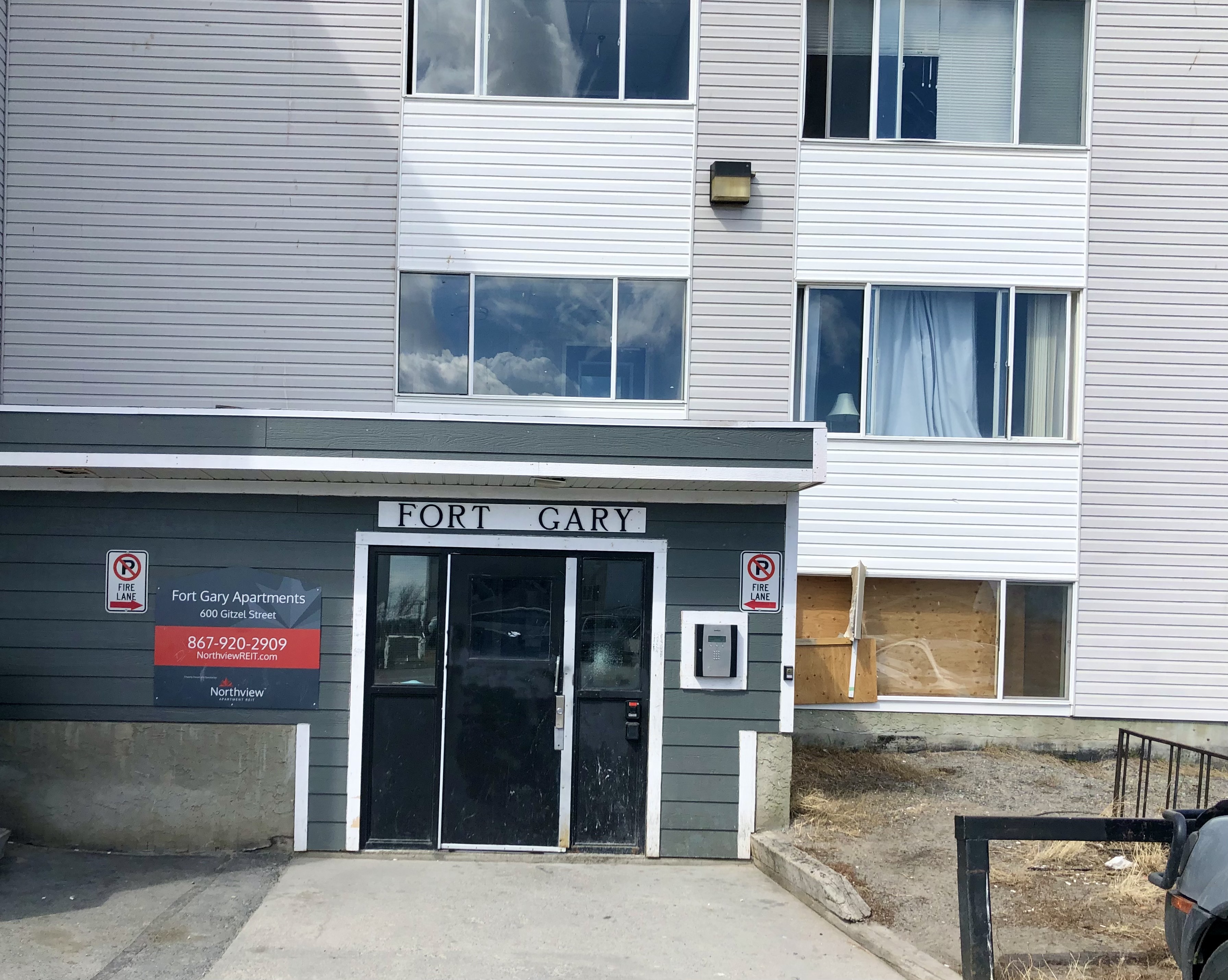 Broken windows at the front entrance to Northview's Fort Gary Apartments in Yellowknife. (Sidney Cohen/CBC)