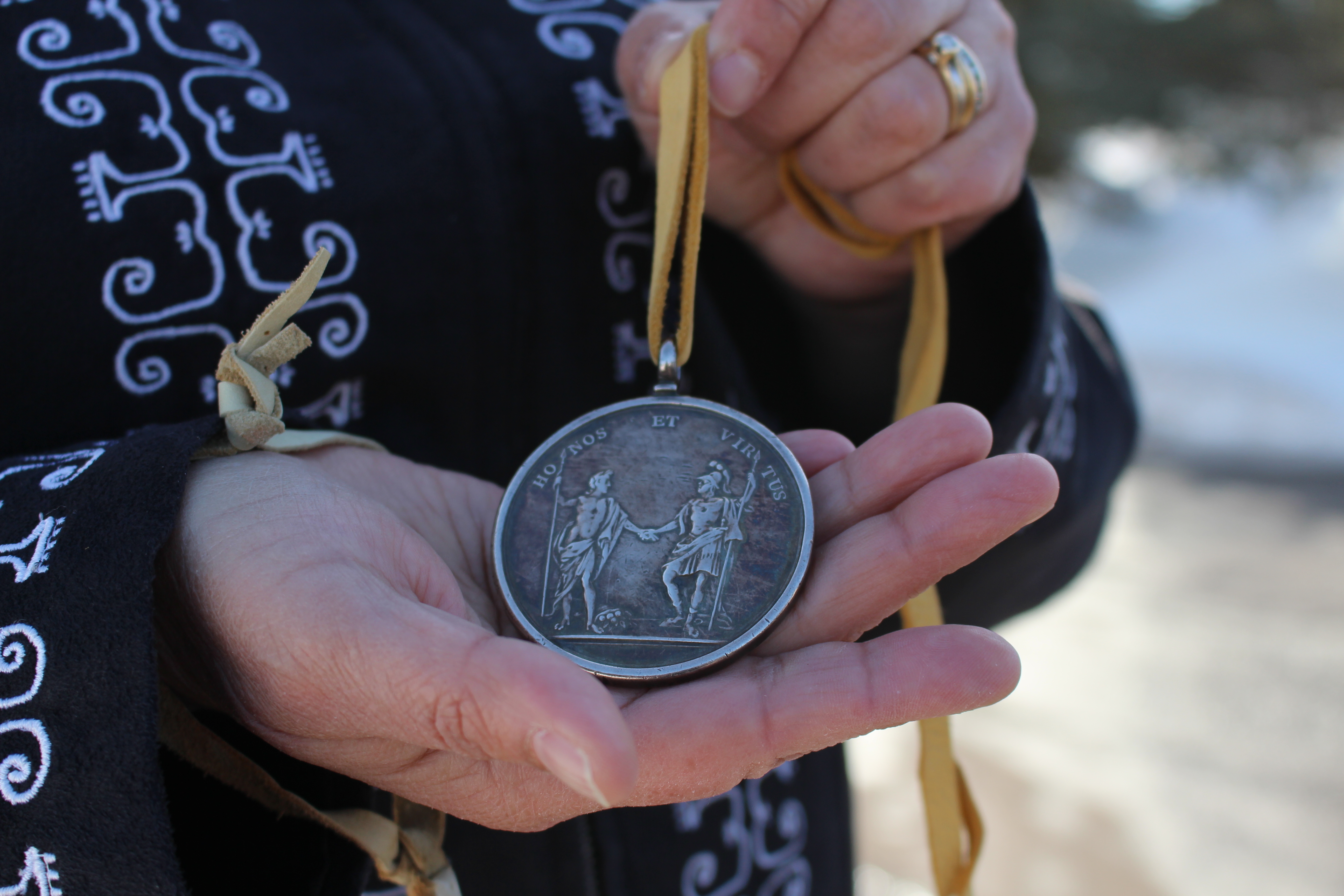 Levi-Peters holds a 300-year-old medal she received from one of the spiritual leaders of Elsipogtog First Nation when she was chief. (Shane Magee/CBC)