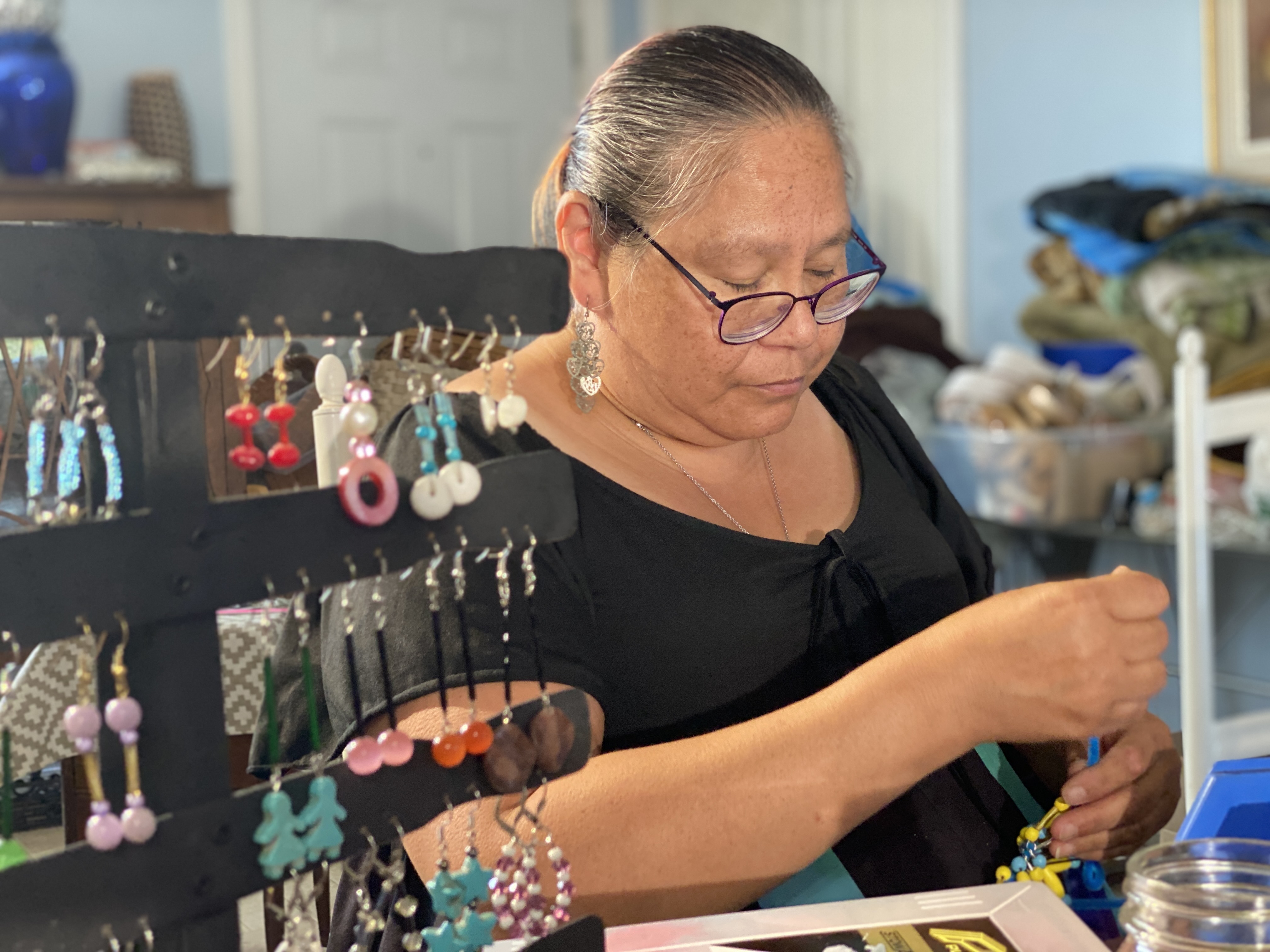 For Patsy Gavin, shown making jewelry at her home on Lennox Island, talking about her school days is anything but nostalgic. She recalls years of fear and abuse. (Kirk Pennell/CBC)