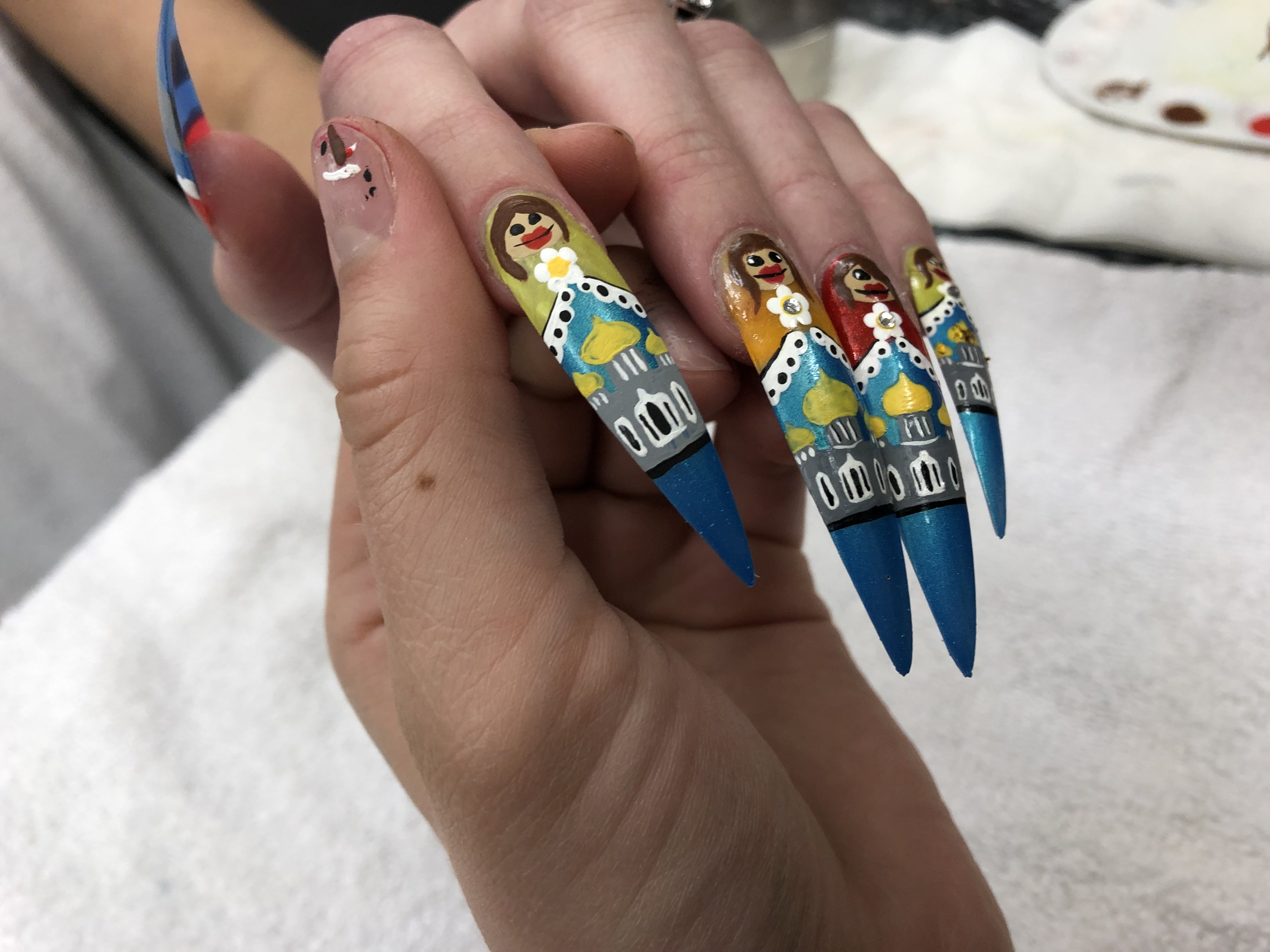 A close up of the finished nails, each one intricately painted to look like a Russian doll.