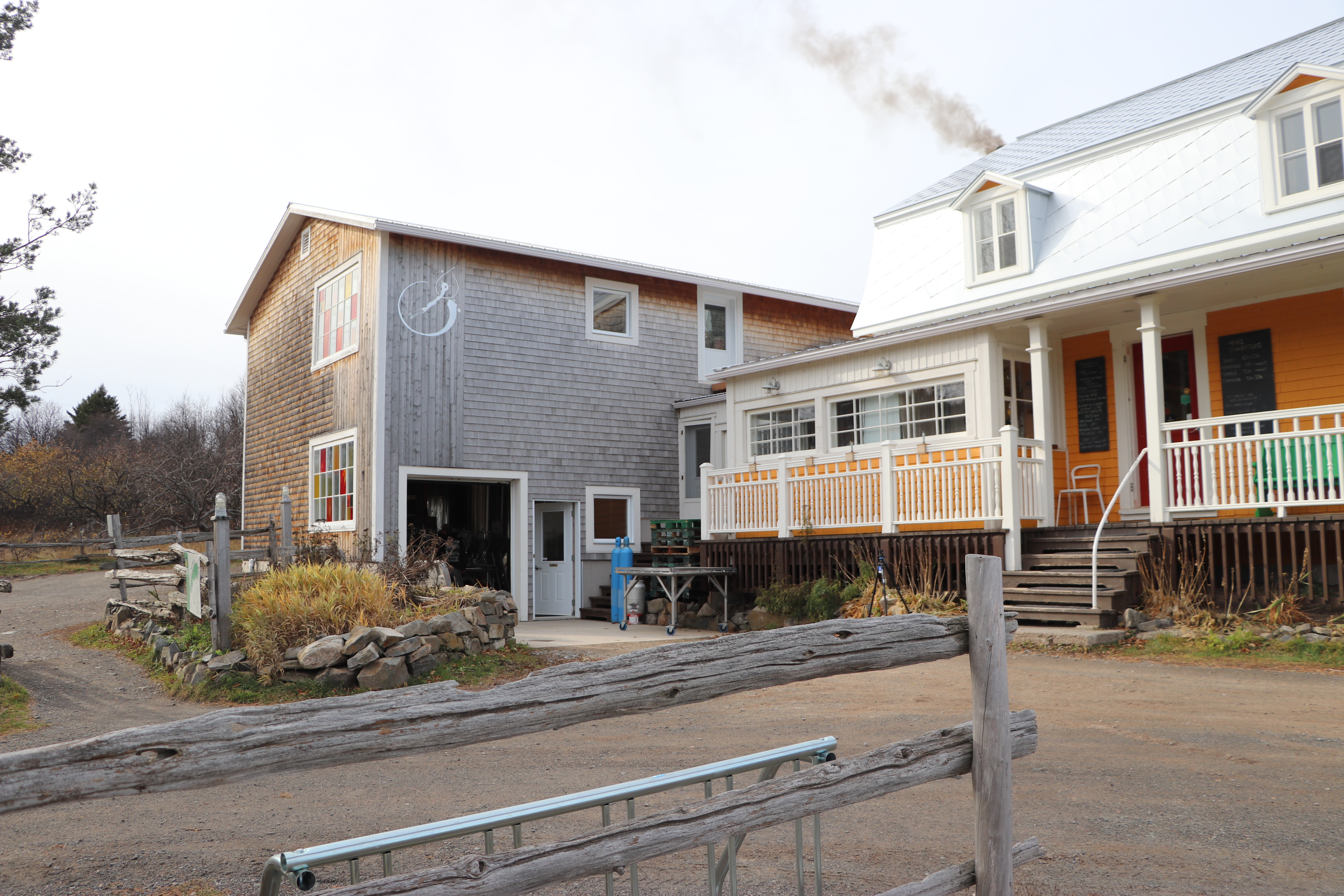 Smoke seeps from the chimney at Tête D’Allumette- where the team throws in extra logs every 3 minutes to make sure the water reaches the perfect boiling point. (Julia Page/CBC)