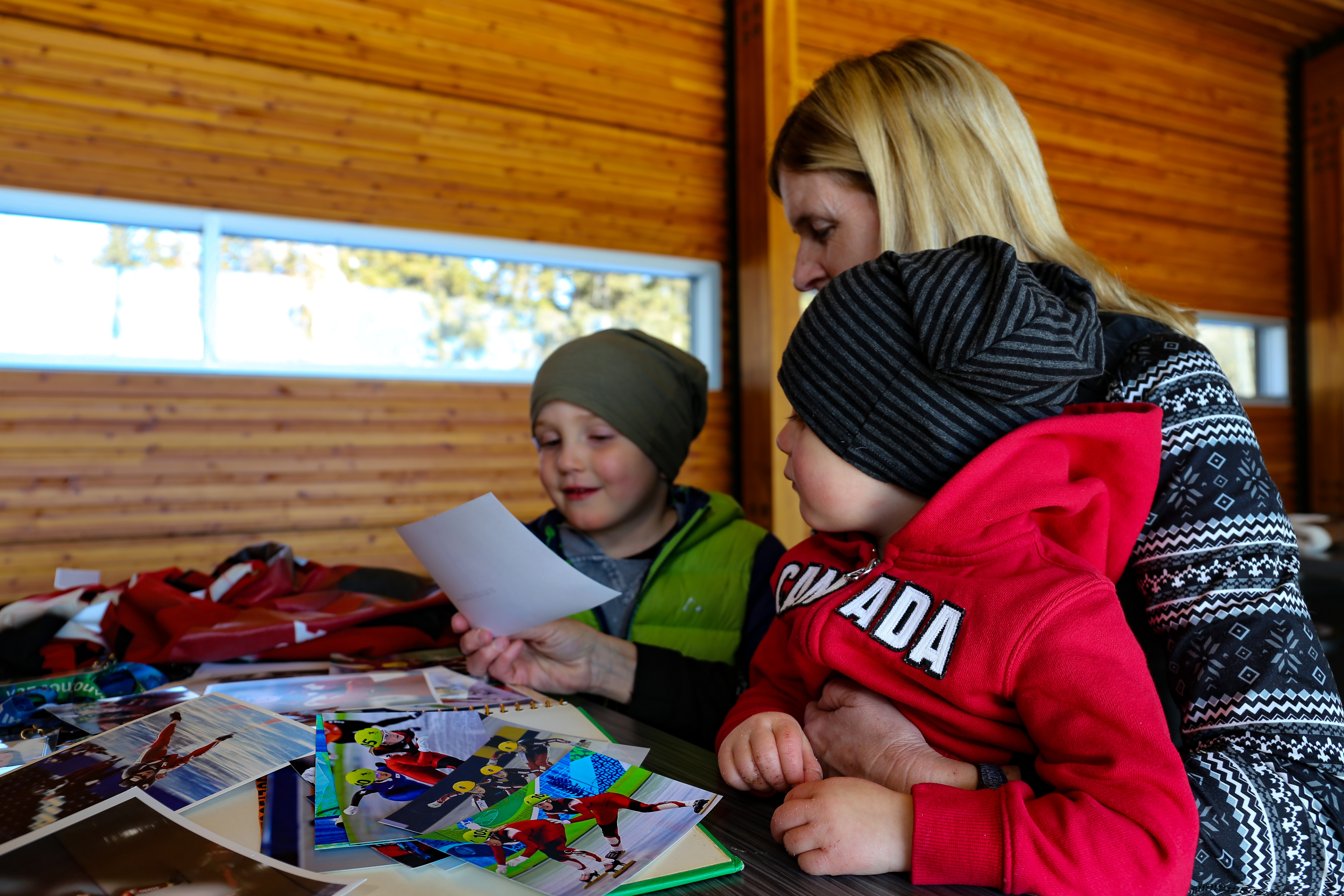 Kathy Gregg reminisces over old skating photos with her grandchildren. (Emily Rendell-Watson/CBC)