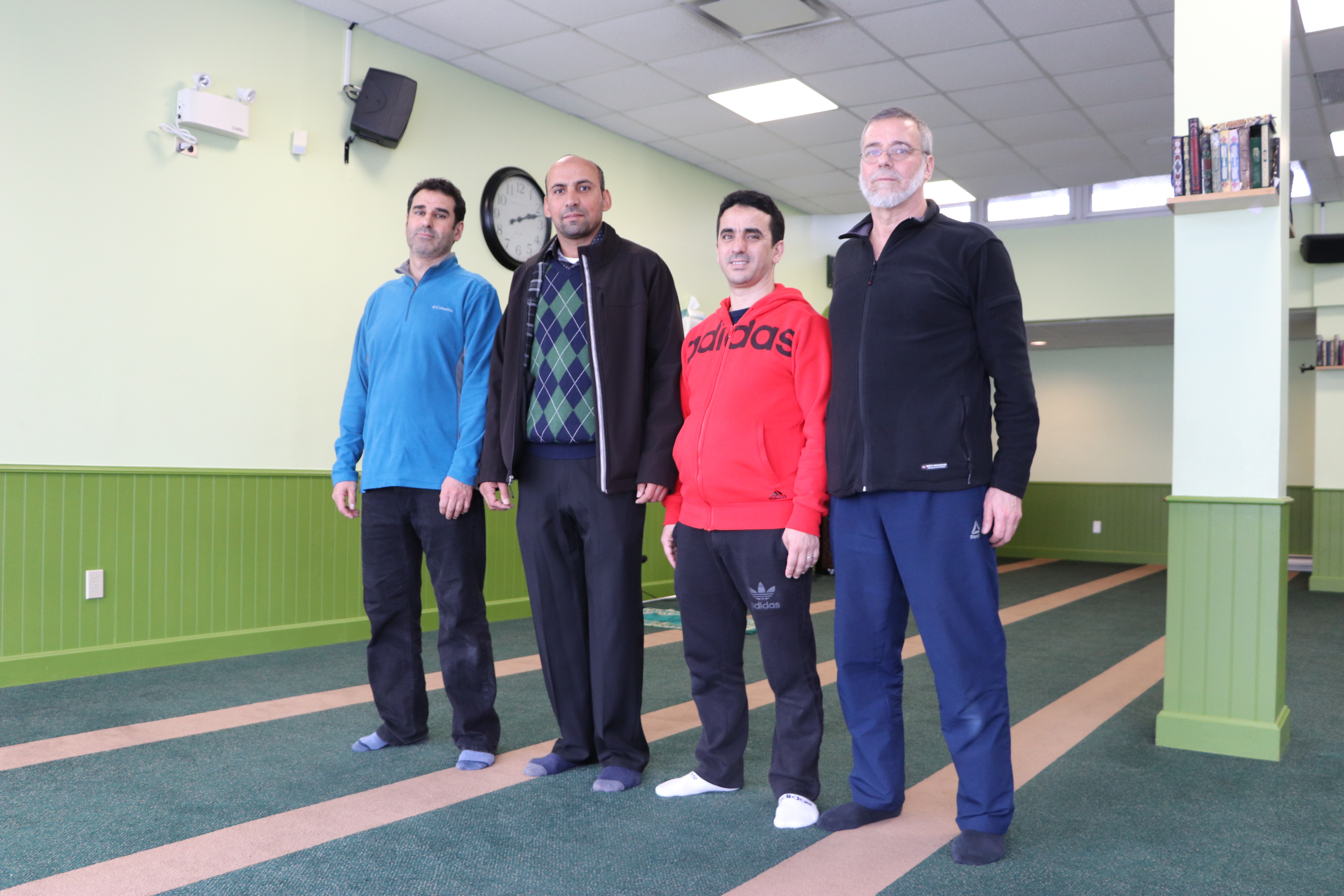 From left, Ahmed Cheddadi, Saïd Akjour, Abdelhak Achouri and Hakim Chambaz, stand in the prayer room at the Quebec mosque in April 2019. (Julia Page/CBC)