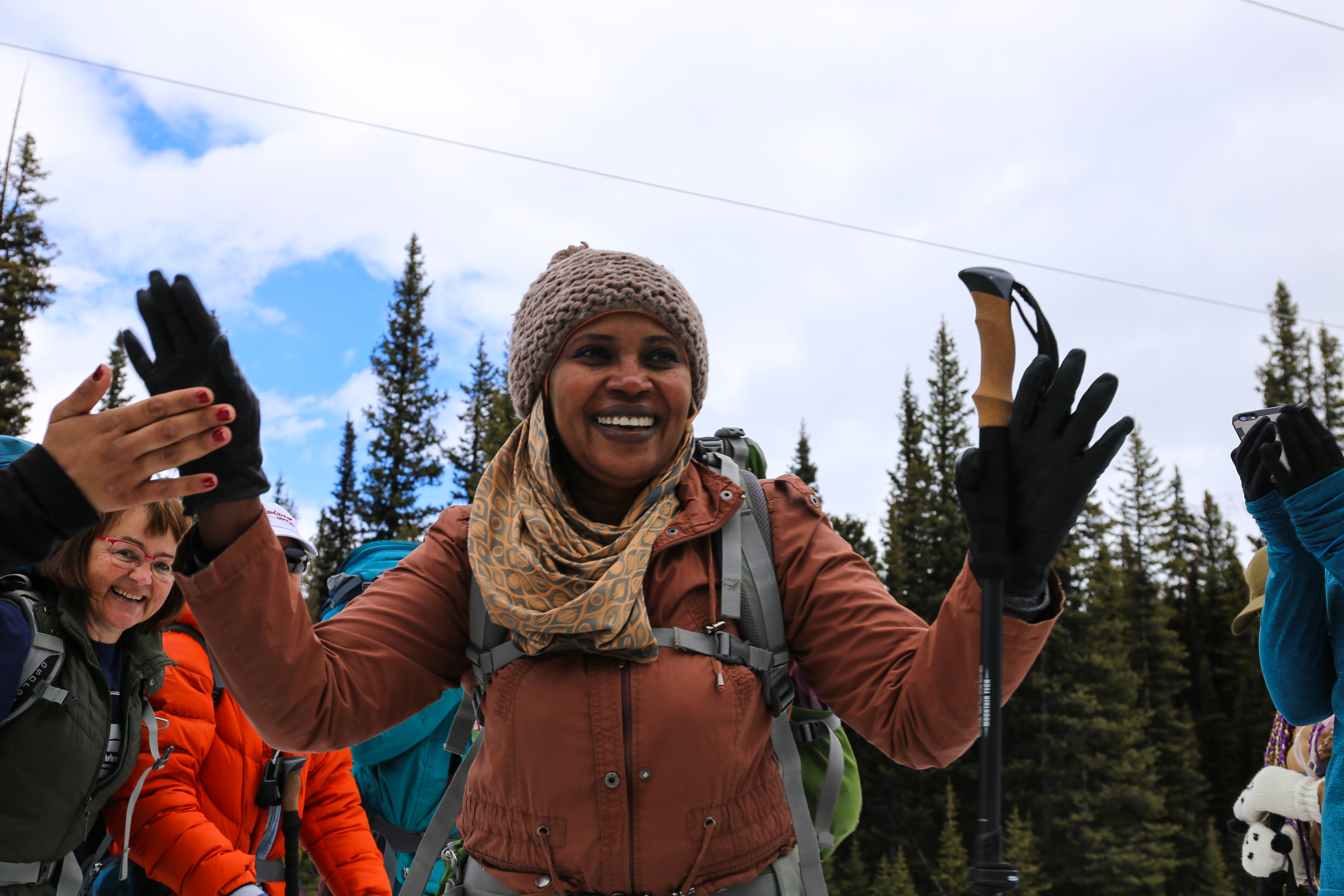 Radia Fadel of Catholic Social Services gets high fives from the group as she arrives at the lunch break spot. (Emily Rendell-Watson/CBC)