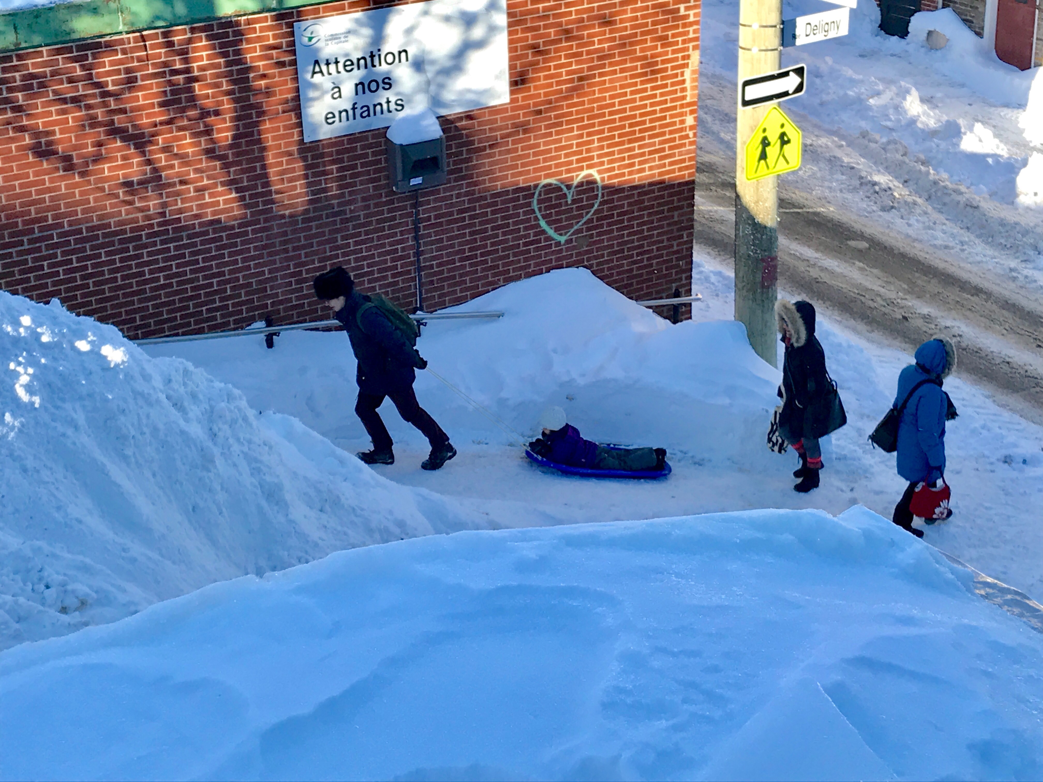 A parent eagerly pulls a reluctant student to class as the school bell rings at École Saint-Jean-Baptiste. (Julia Caron/CBC)